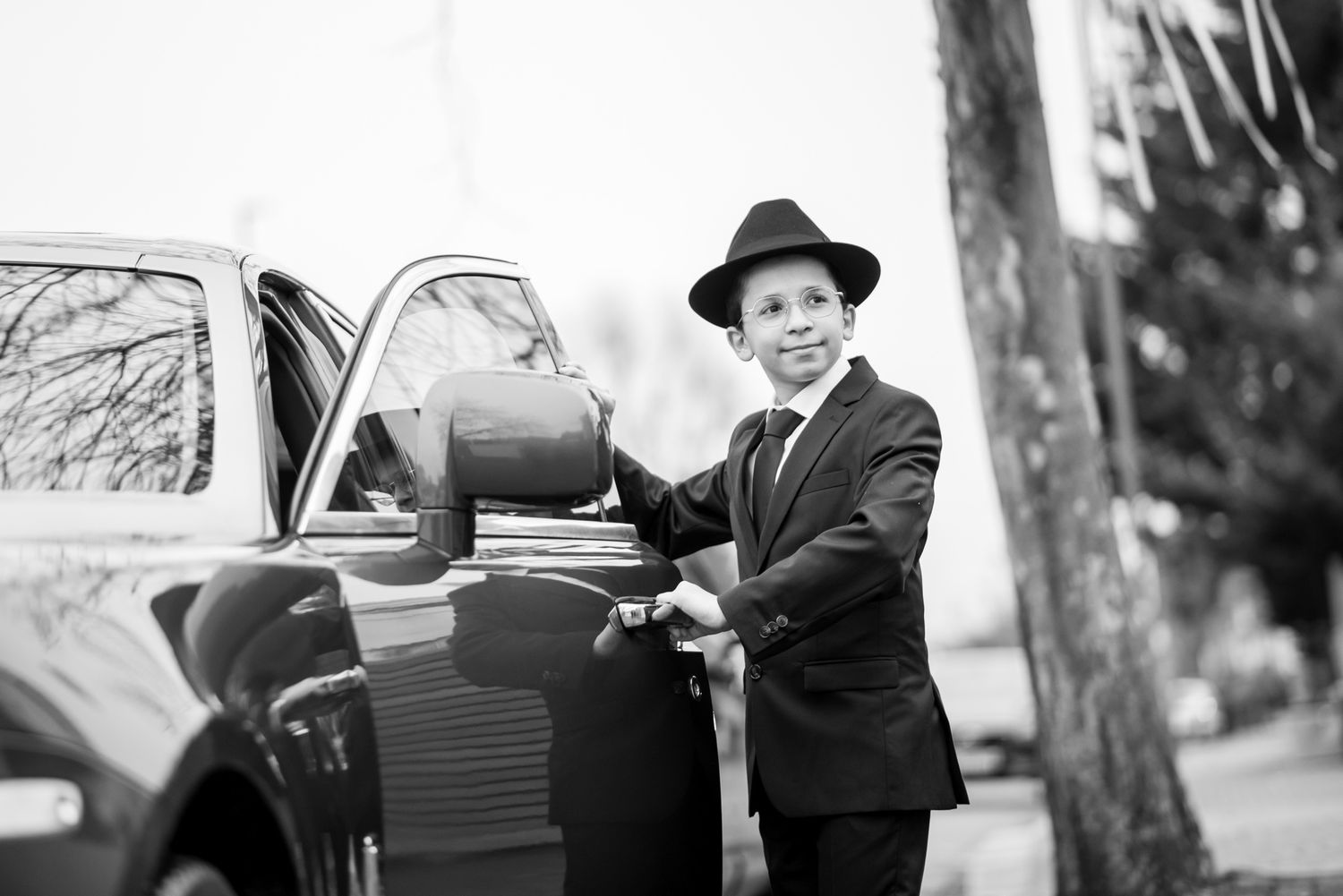 A black and white photo montage showing vintage cars and people in formal attire from the 1940s era.