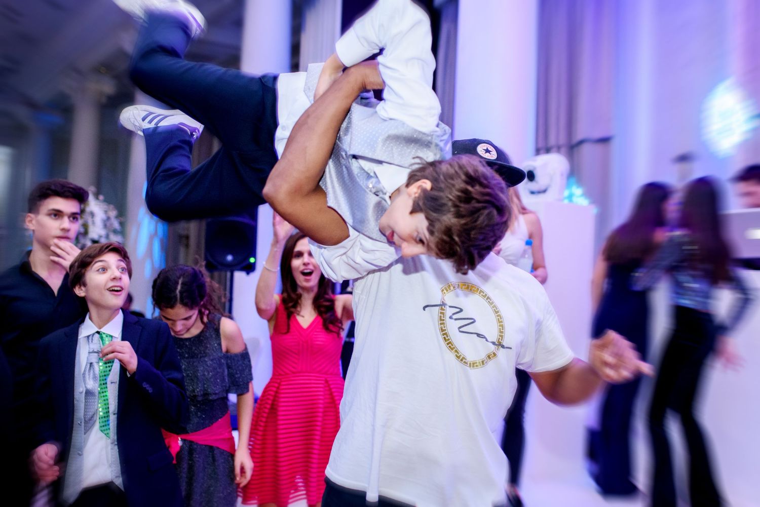 Couples dancing together at an elegant wedding reception with blue and purple lighting effects.