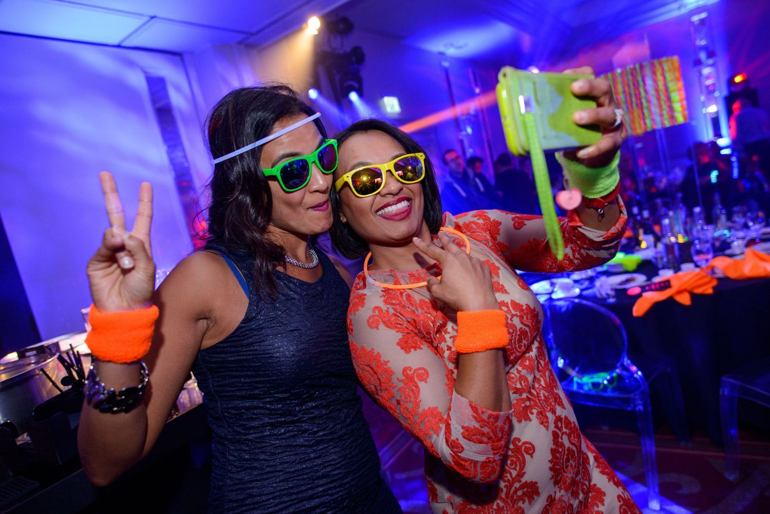 People dancing and celebrating at a nightclub with vibrant blue lighting and energetic atmosphere.