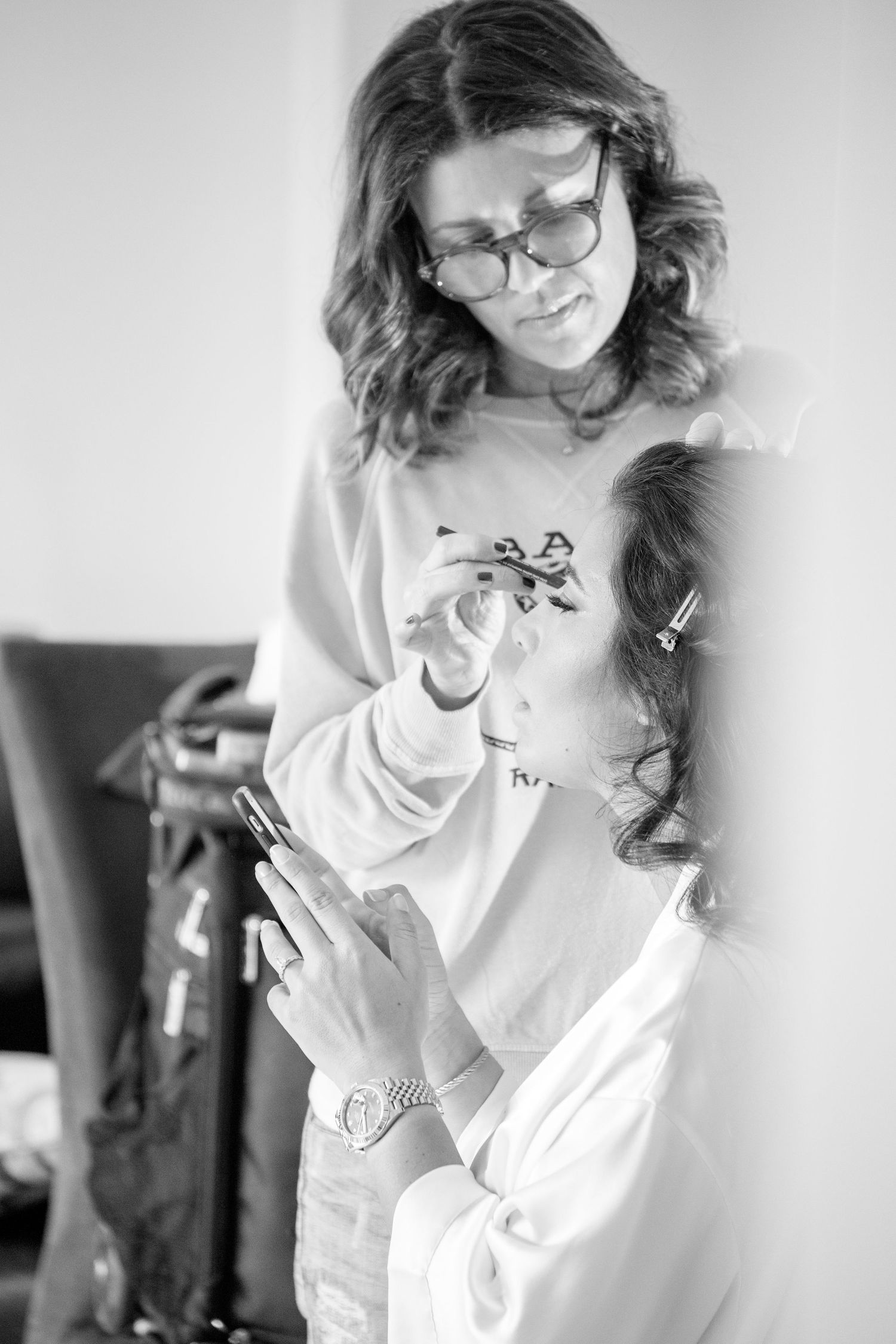 Black and white photo series showing a person wearing glasses and a white shirt laughing and smiling in casual poses.