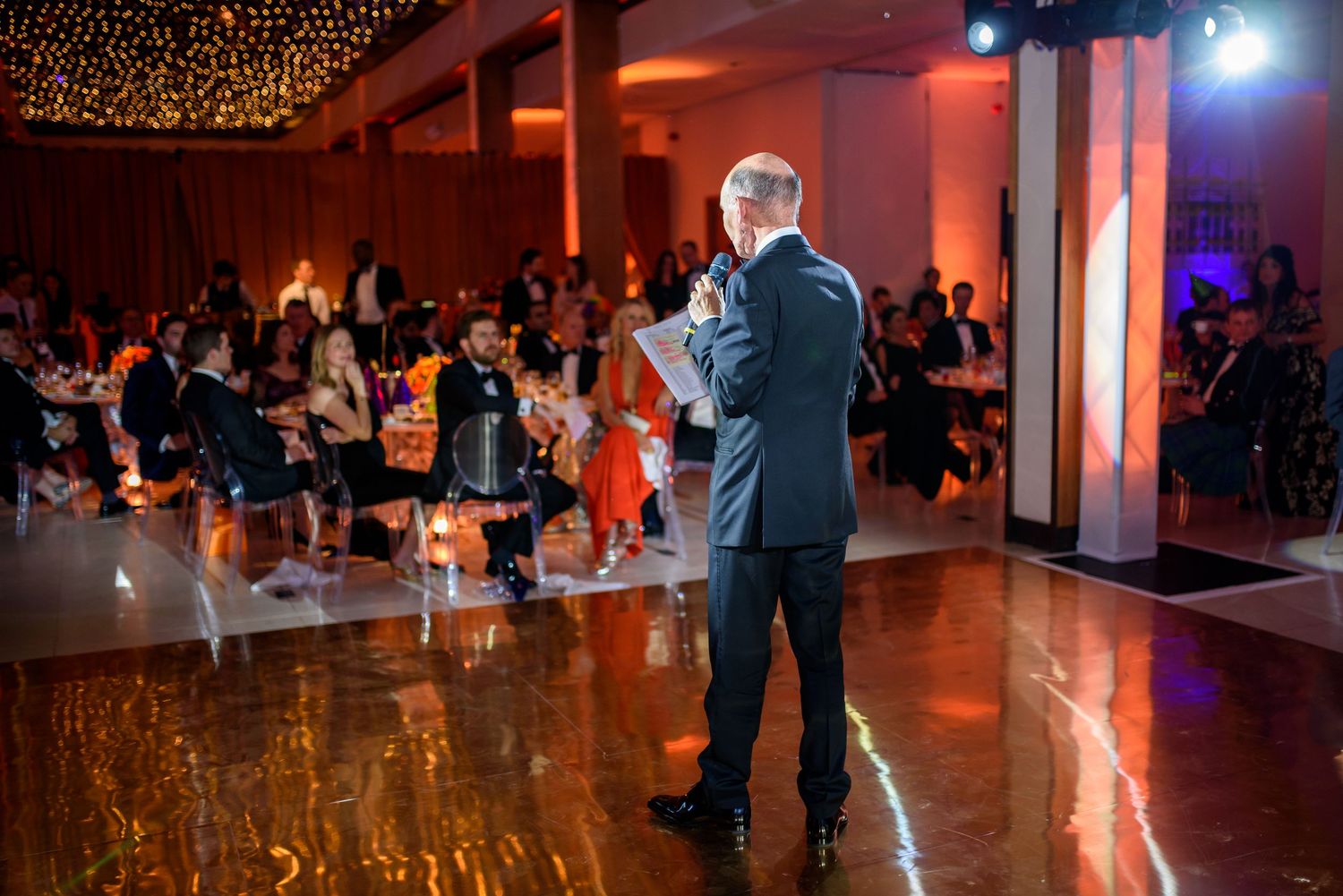 Event venue decorated with string lights and colored uplighting creating an atmospheric ambiance.