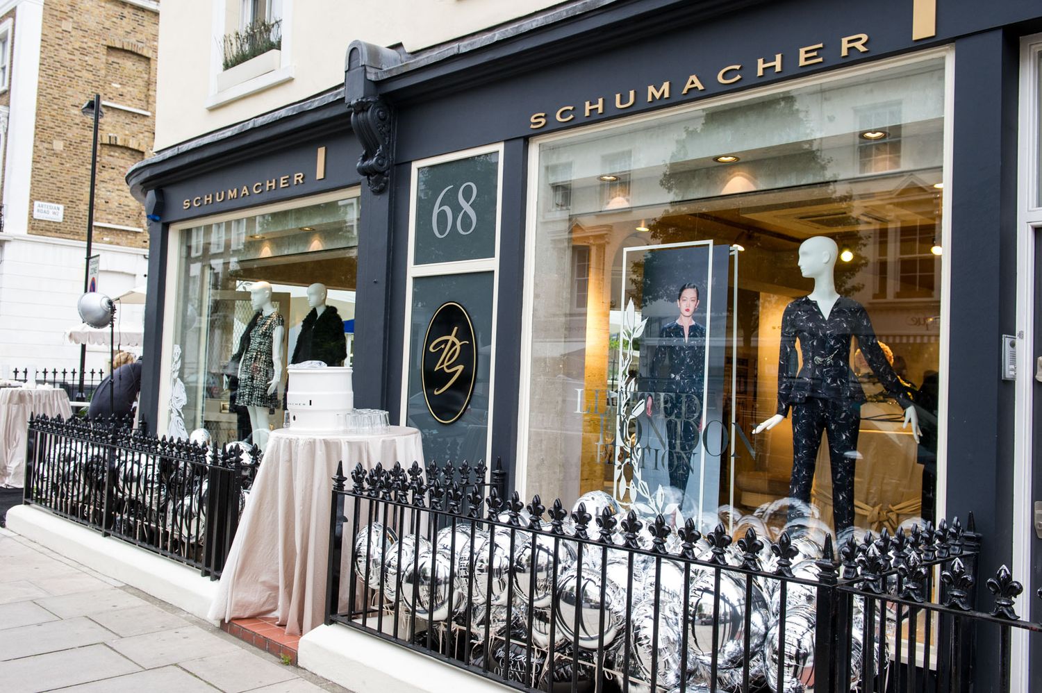 Row of upscale retail storefronts with classic London-style architecture.