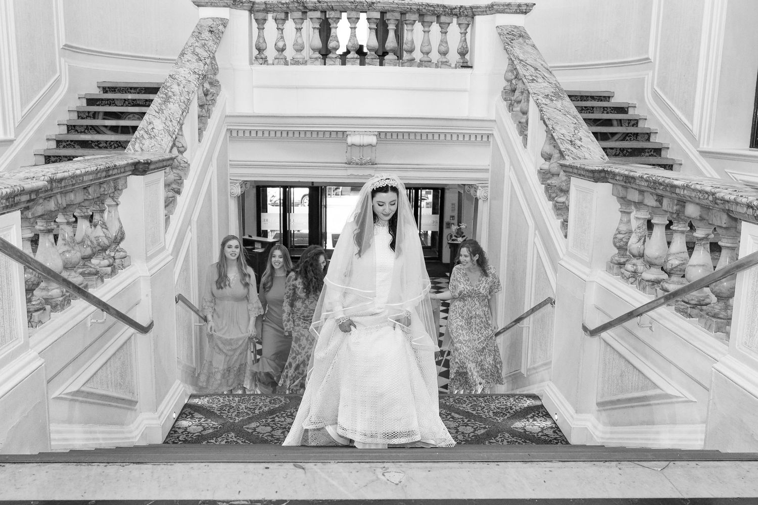 A series of wedding photos showing couples posing on an ornate white marble staircase in a grand venue.