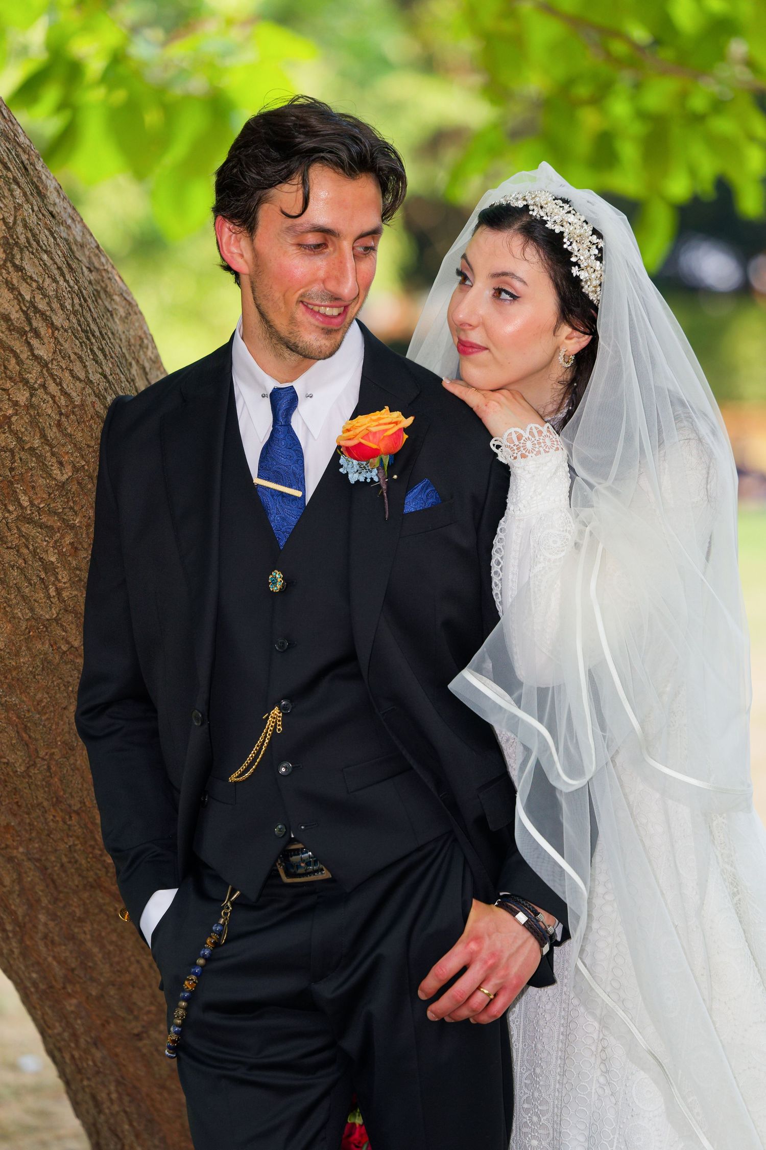 A romantic wedding couple shares tender moments outdoors under a tree in a series of candid photos.