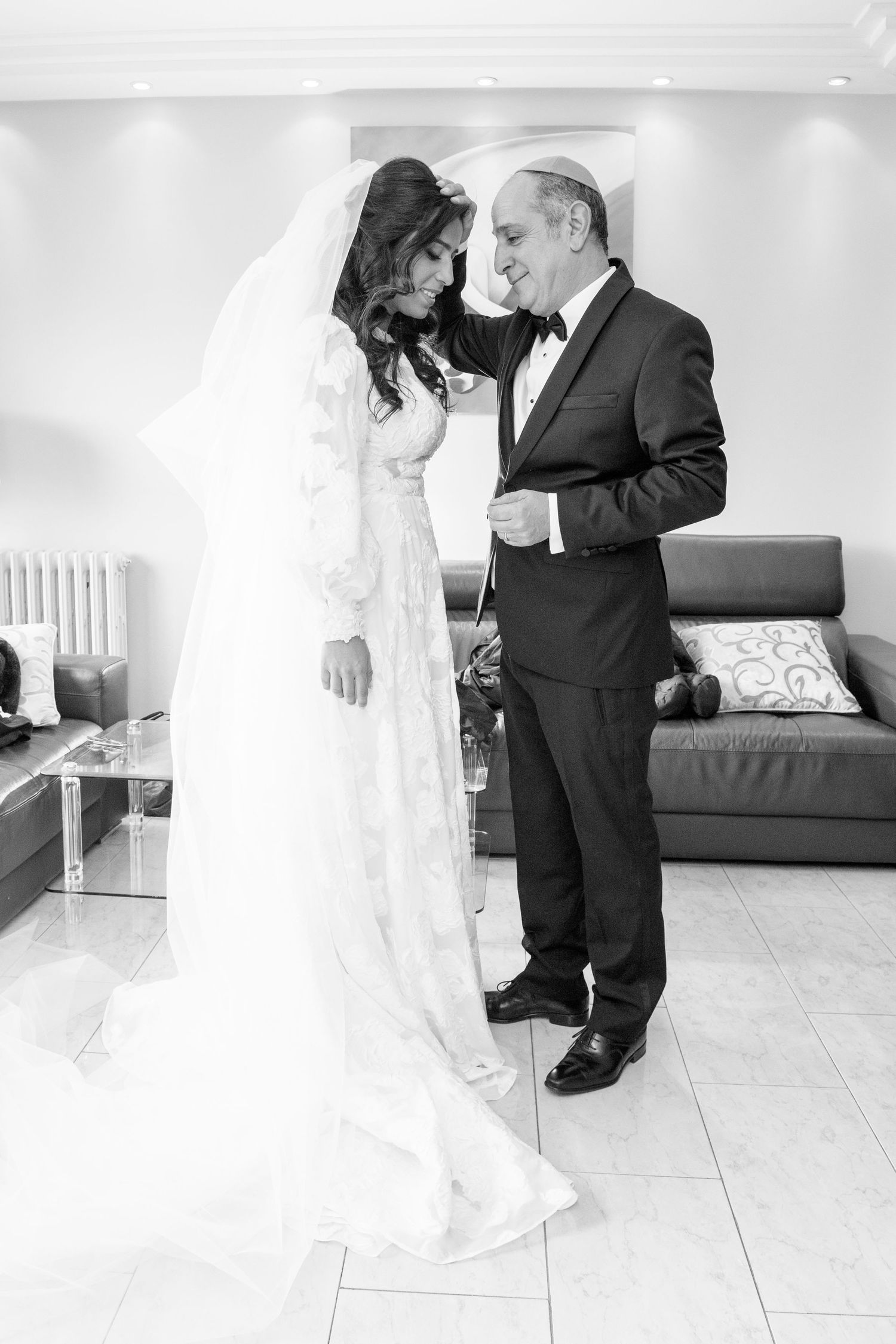 A tender first look moment between a bride in white and groom in black suit during their wedding day.