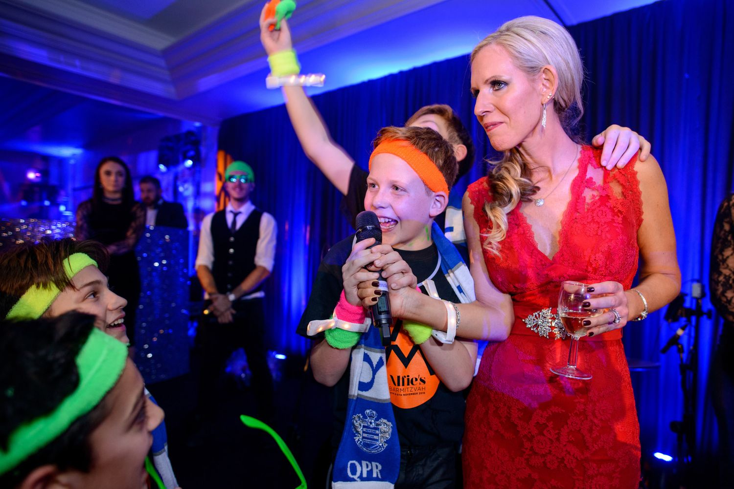 Wedding reception party with blue lighting and guests dancing.