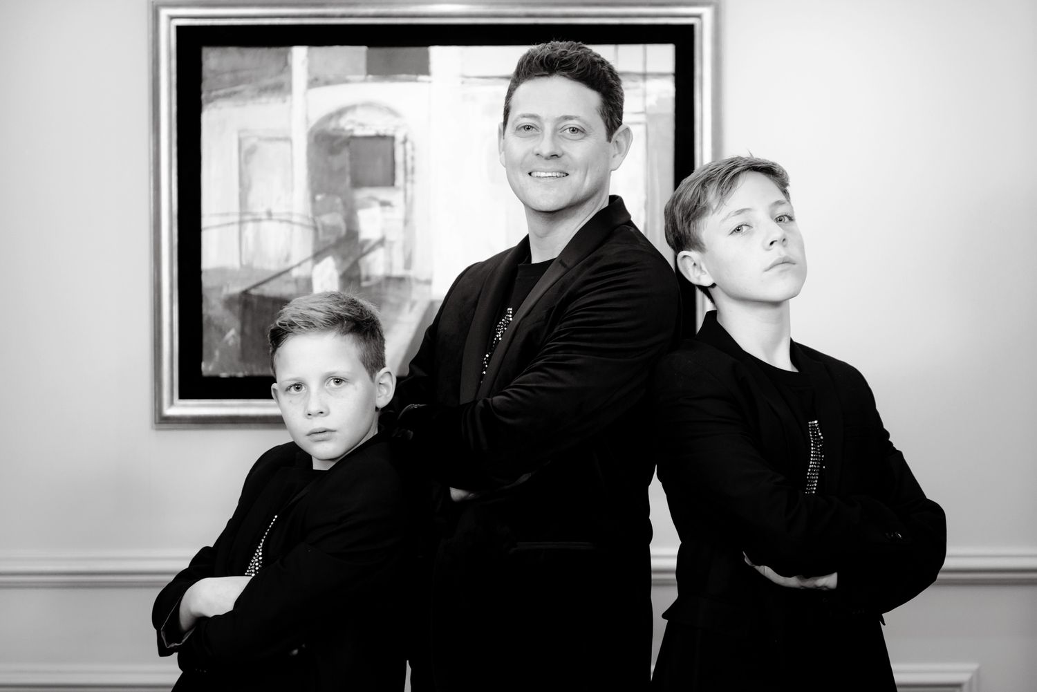 A series of black and white portraits showing people in formal attire posing against a light background.