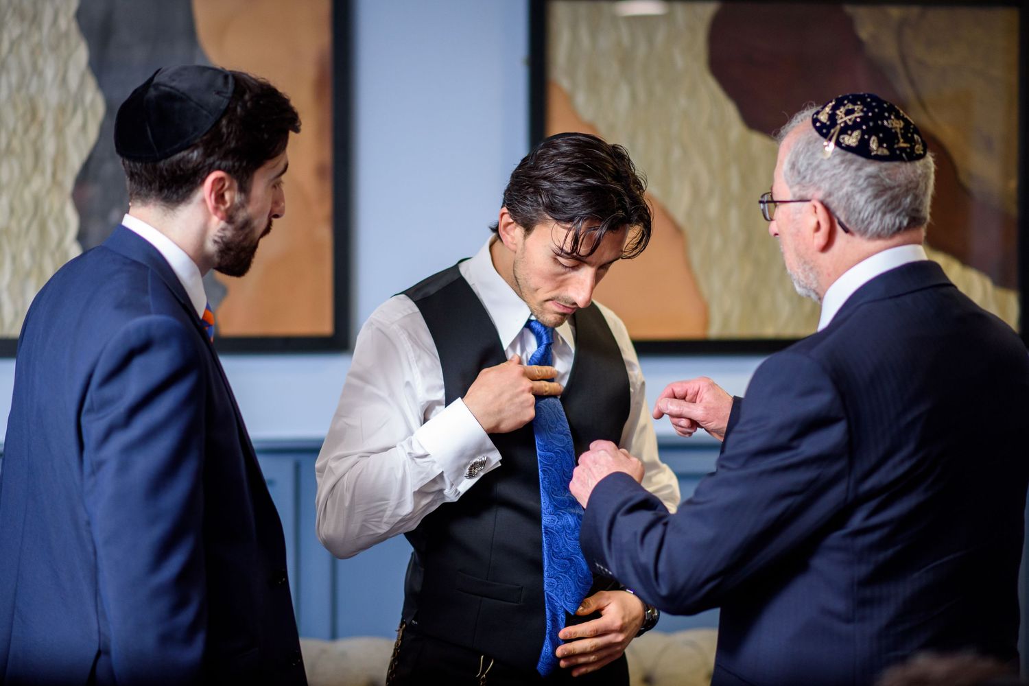 Sequence of candid wedding photos showing emotional embraces and moments between people in formal attire.
