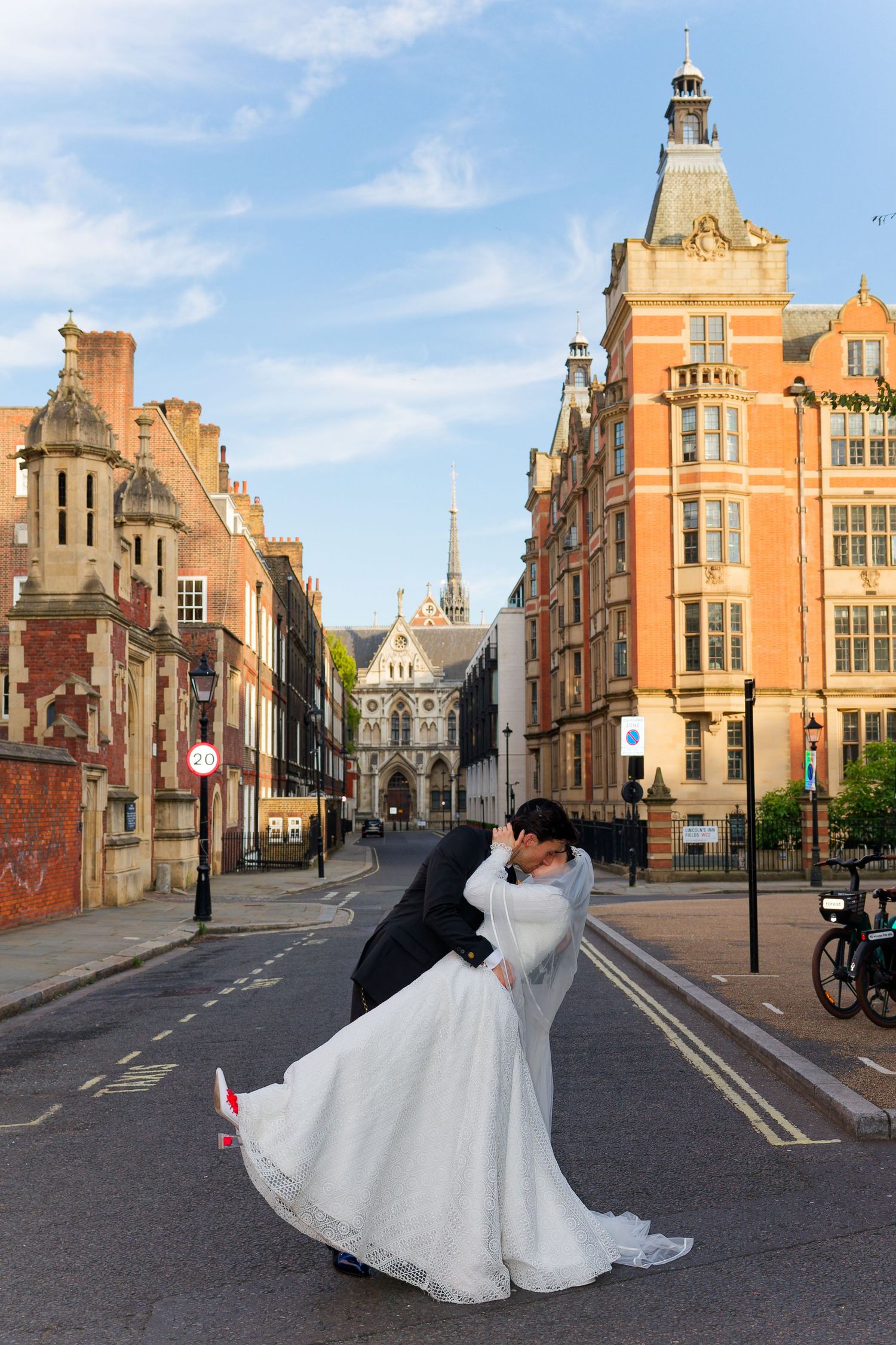 A romantic scene unfolds on a historic cobblestone street with Tudor-style architecture and a church spire in the background.