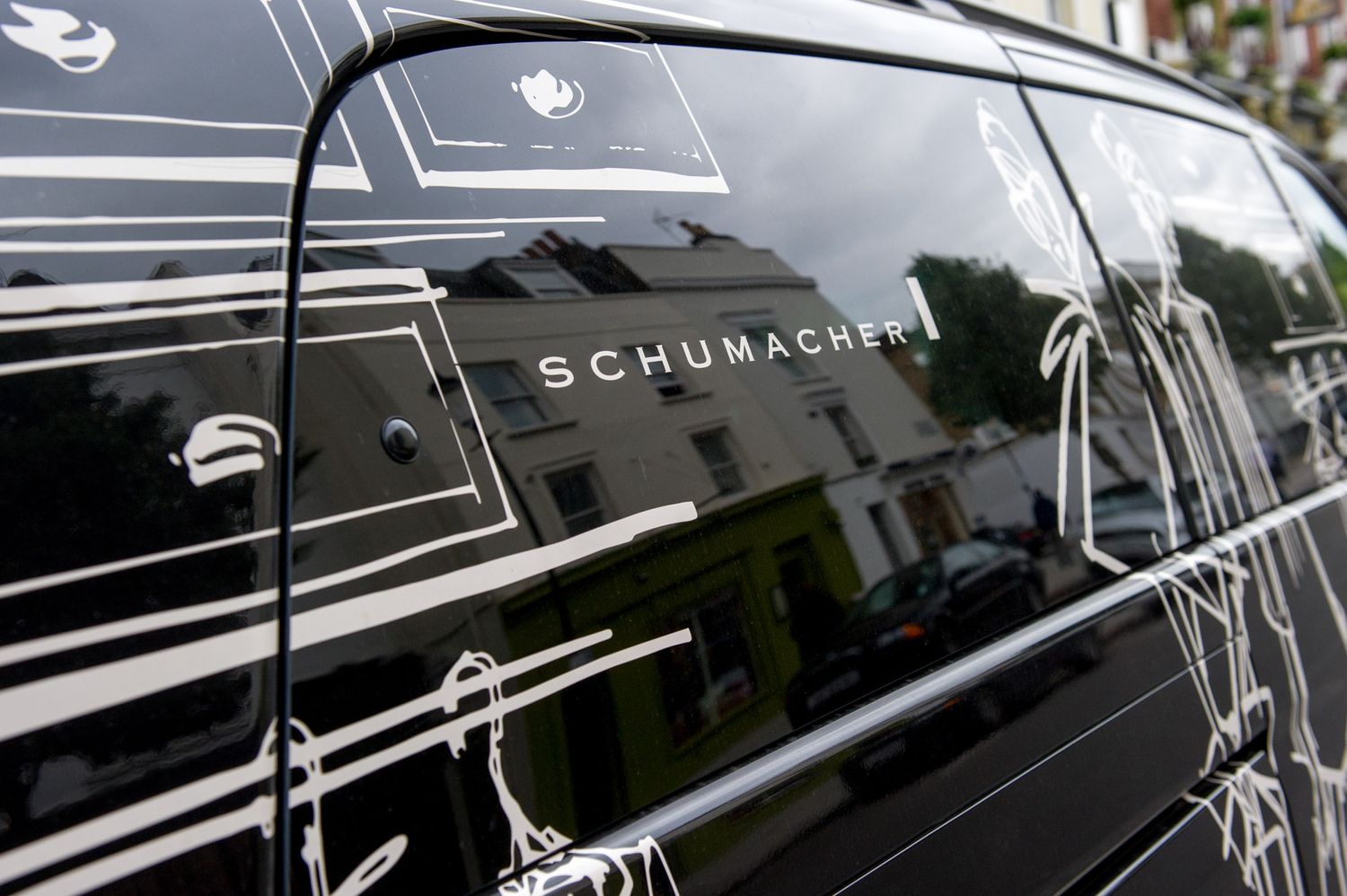 Close-up of Schumacher branding on a sleek black luxury vehicle.