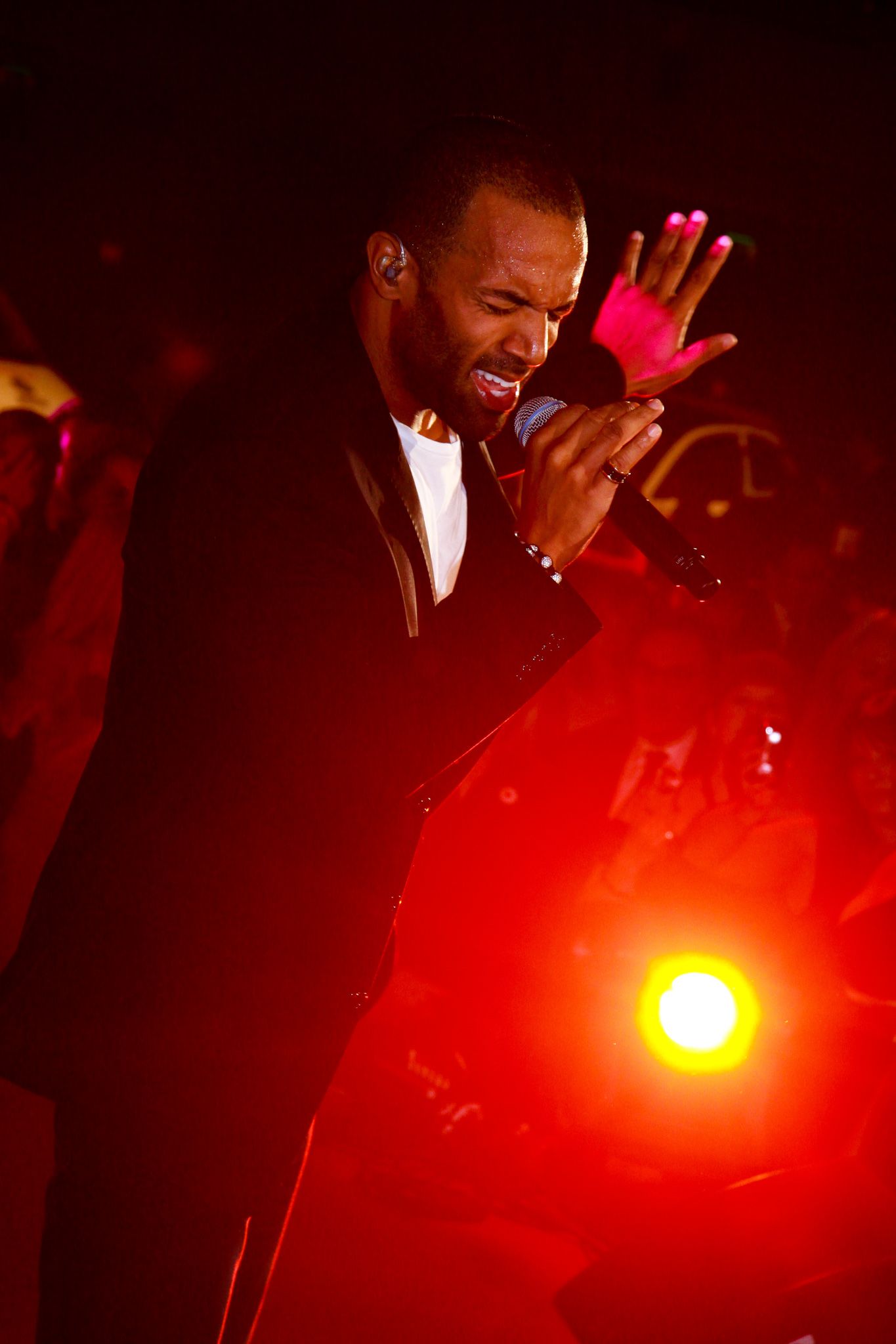 Stage performer silhouetted against dramatic red lighting during a show.