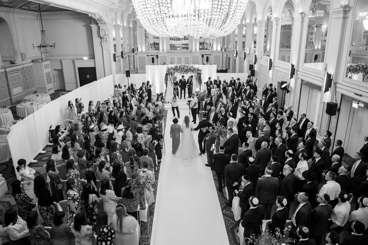 A large crowd of people gathered in a hallway during what appears to be a business or academic networking event.