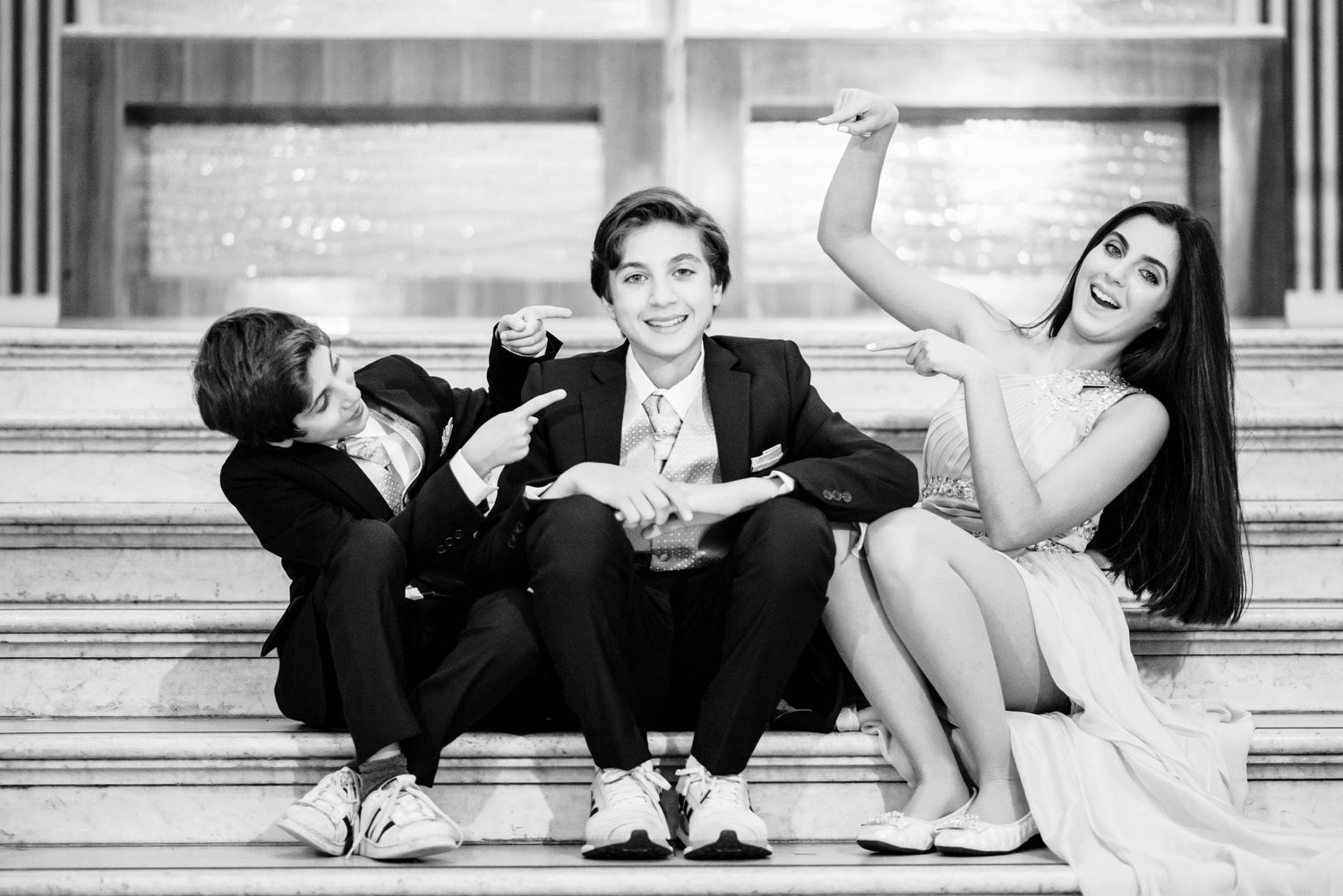 A series of black and white photos showing people sitting and posing playfully on outdoor steps.