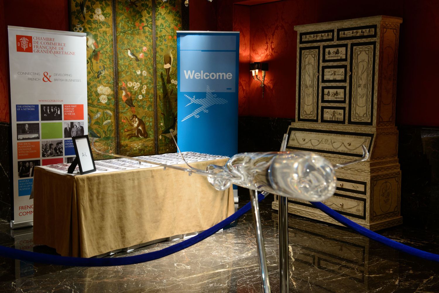 Elegant event space with gold wallpaper and branded display materials.