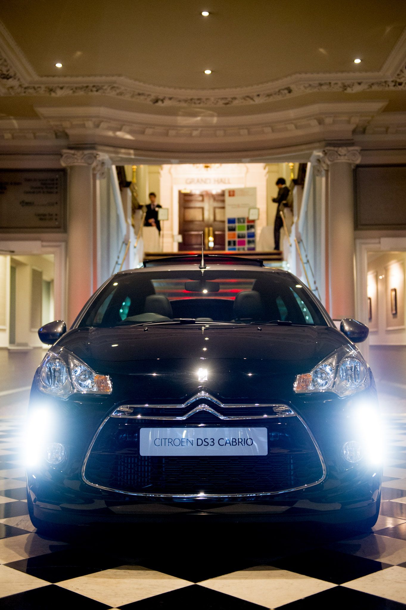 Front view of luxury Citroen DS5 cars with headlights on in an elegant showroom.