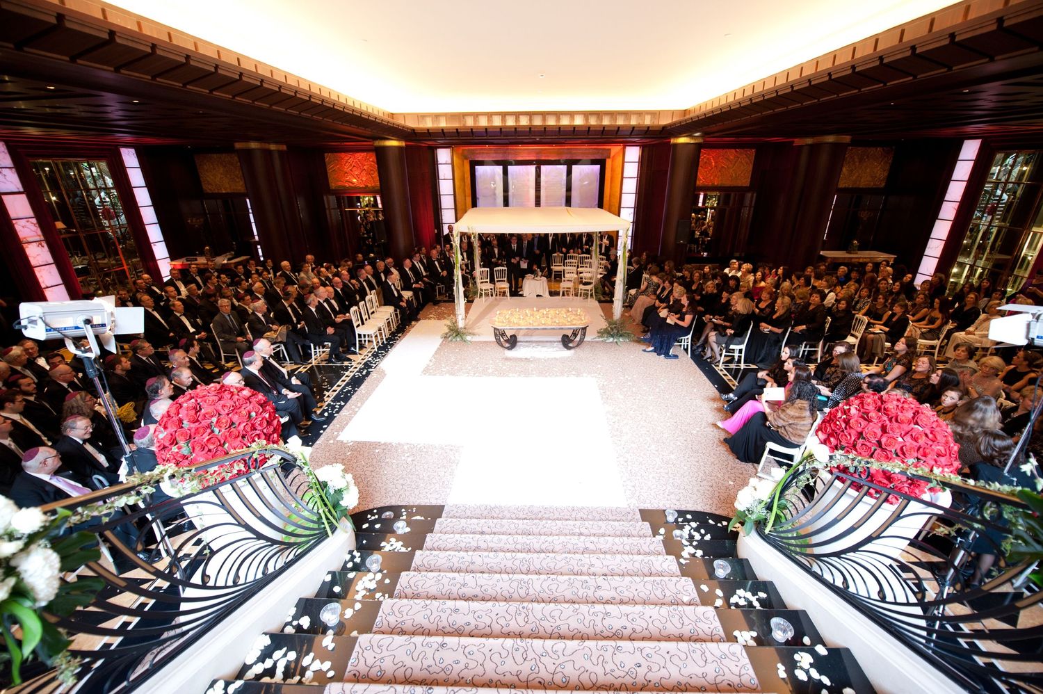 A panoramic view of a grand ballroom with elegant decor and rows of seated guests at a formal event.