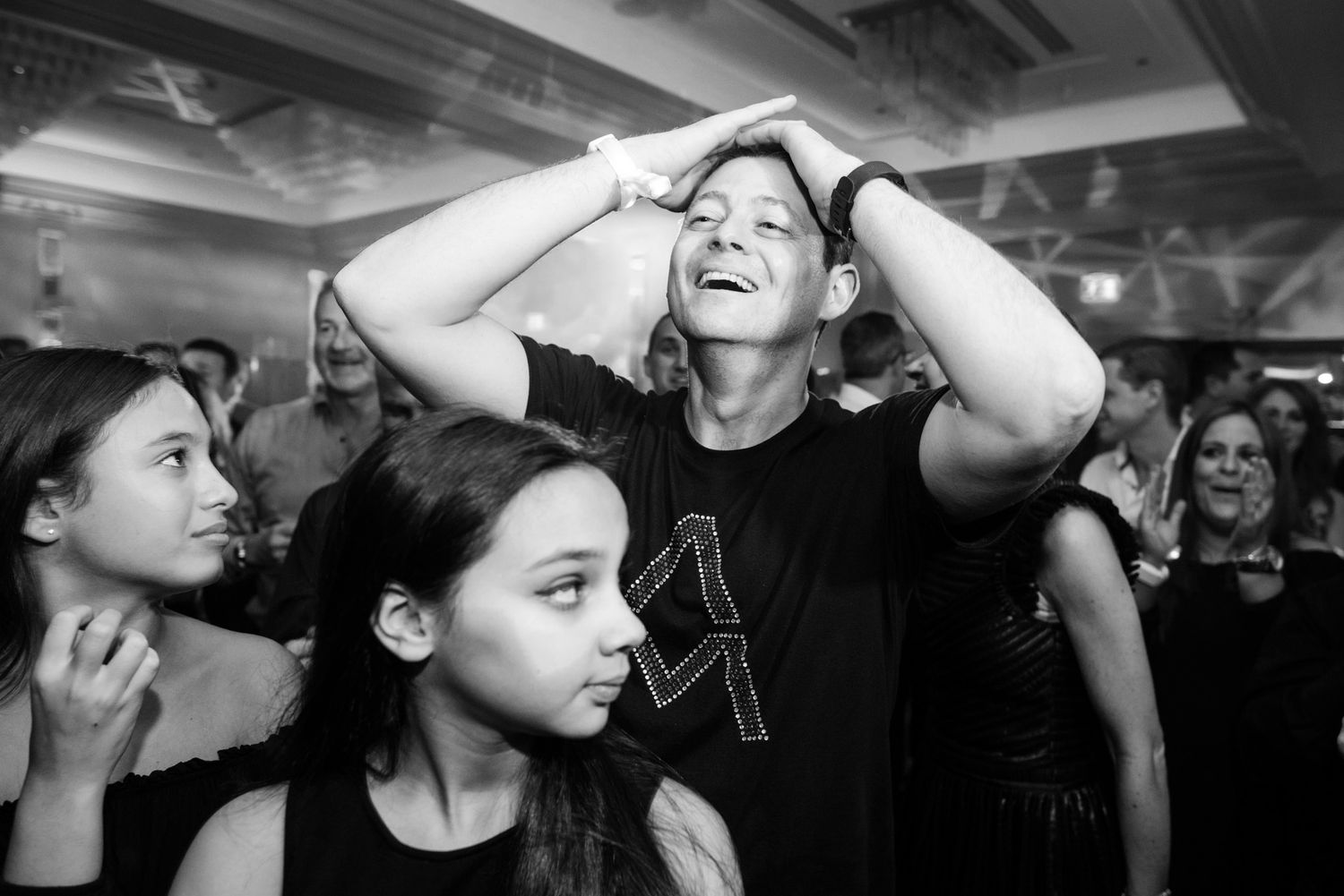 Black and white photo showing people dancing and enjoying themselves at what appears to be a concert or club event.