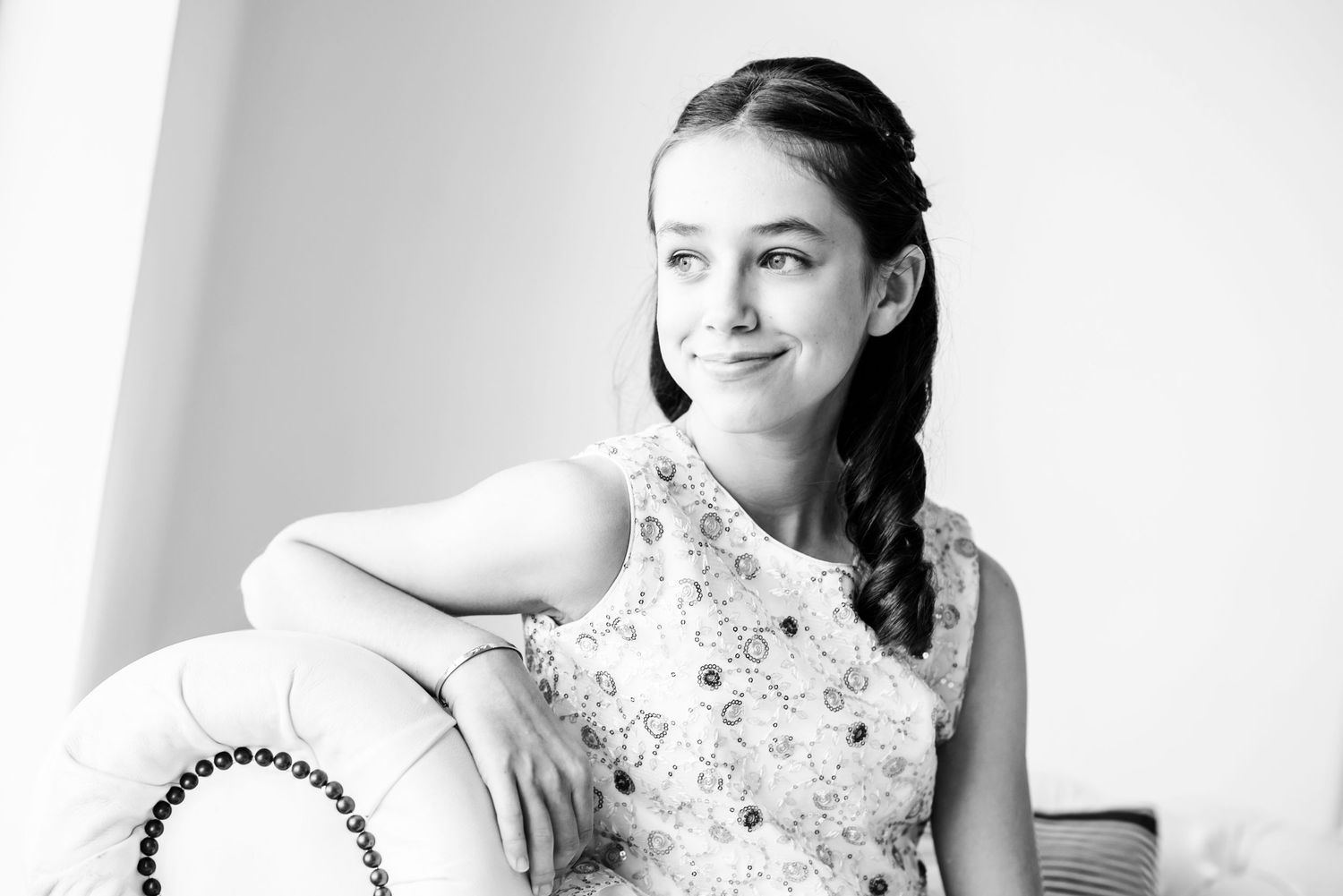 A person in a white lace dress poses gracefully in a series of black and white portrait photographs.