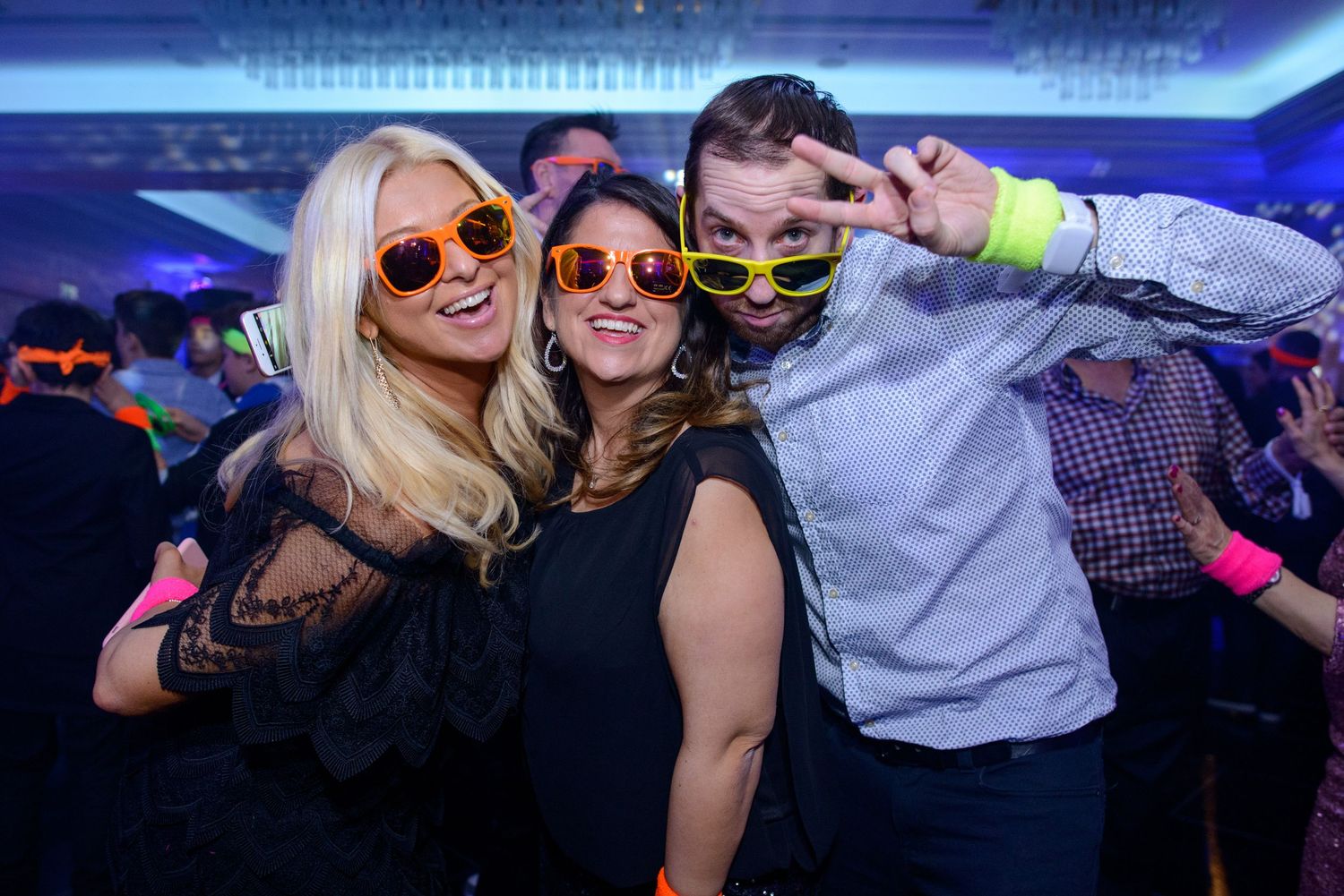 People dancing and having fun at a nightclub with blue lighting and party atmosphere.