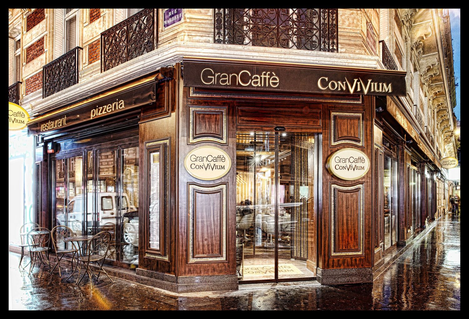 Panoramic view of classic Parisian cafe exterior with ornate woodwork and signage.