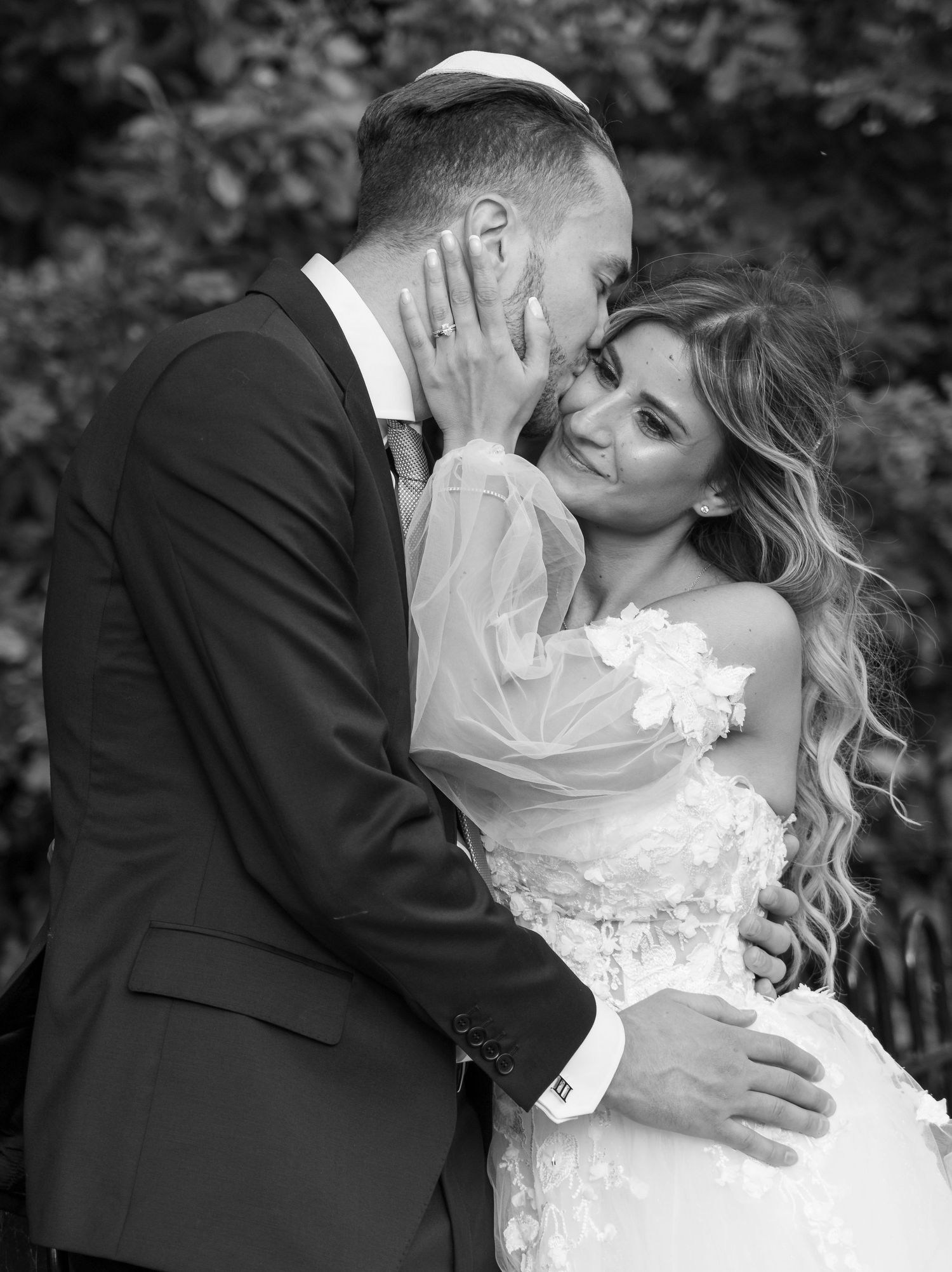 A romantic black and white photo series showing a couple in wedding attire sharing intimate kisses and embraces.