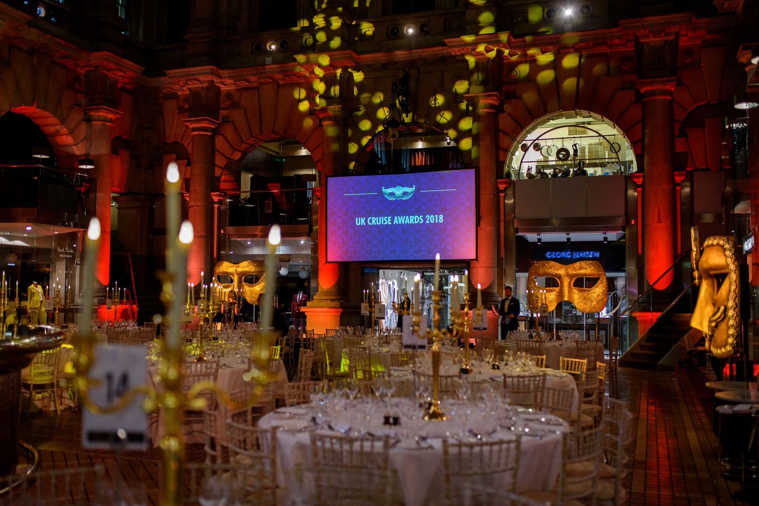 Elegant event space with round dining tables and ambient lighting.