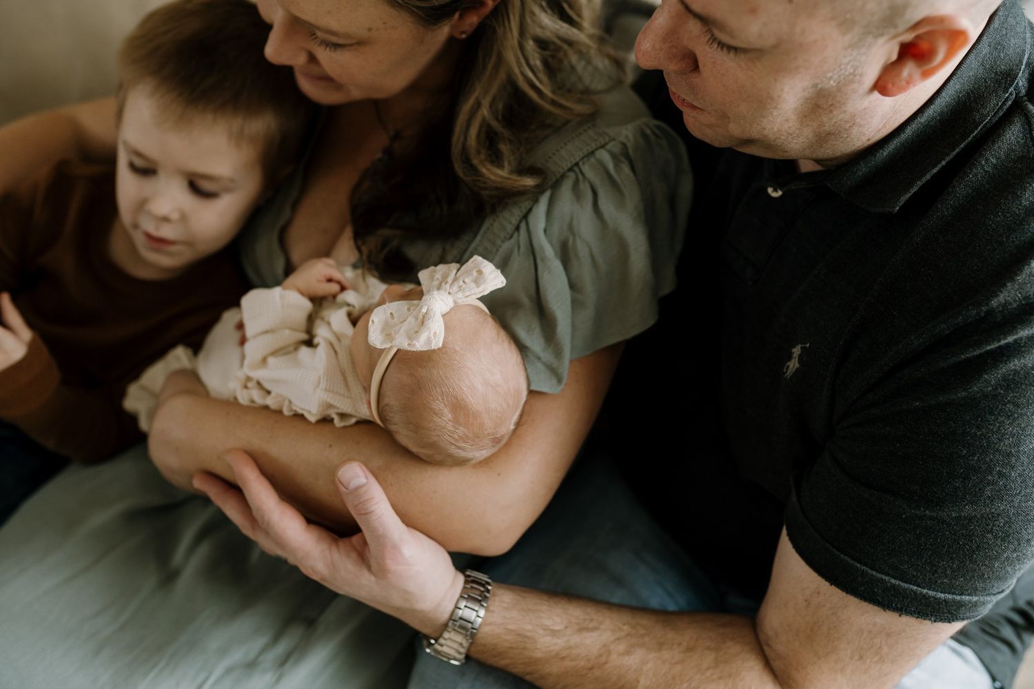 family cuddles together on couch during newborn session knox county newborn photographer