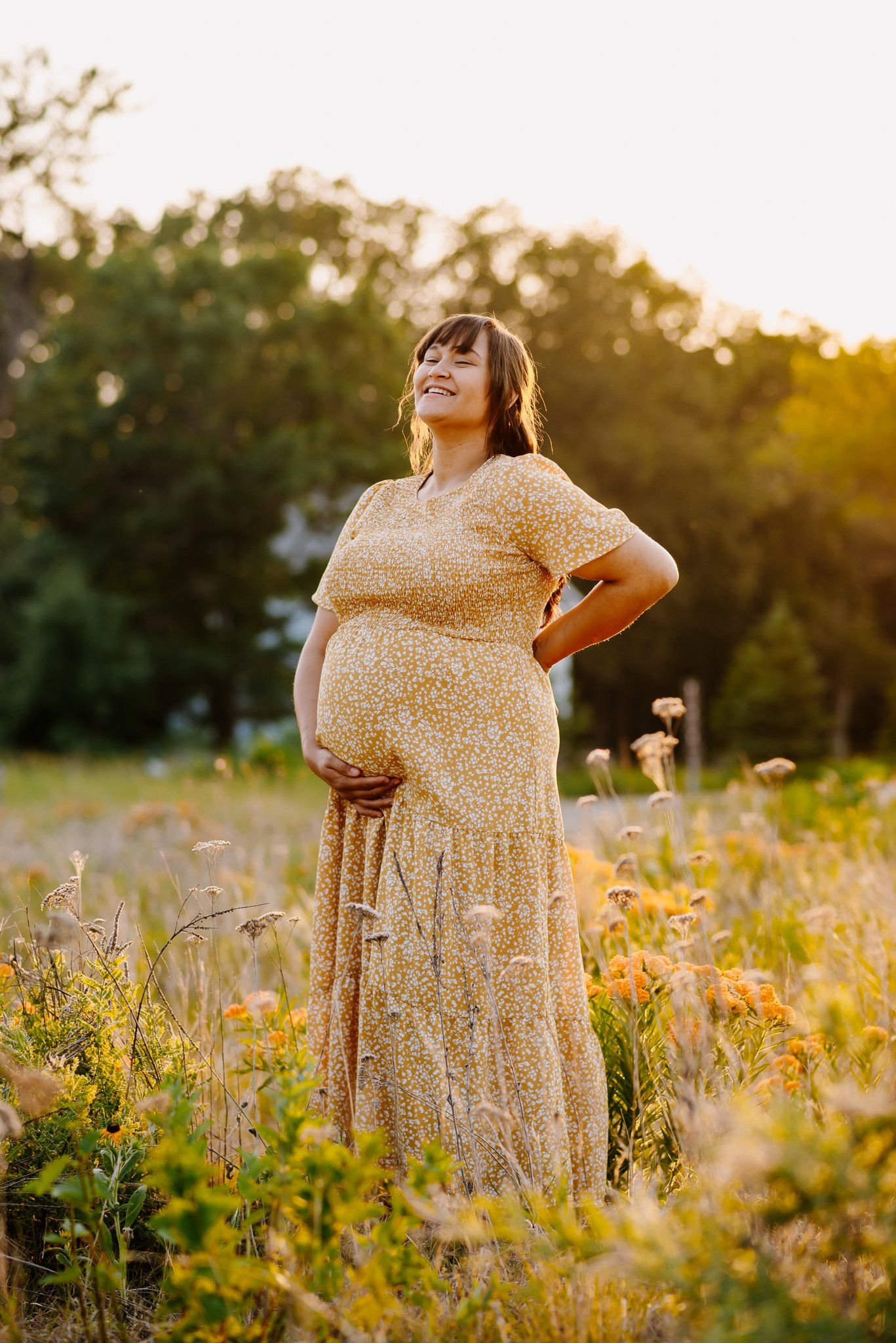 summer maternity photo of mom standing in a field of wildflowers
