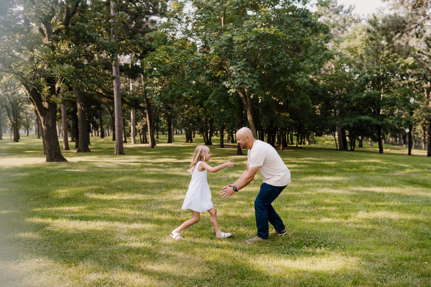 Dad plays with his daughter as she runs to jump into his arms
