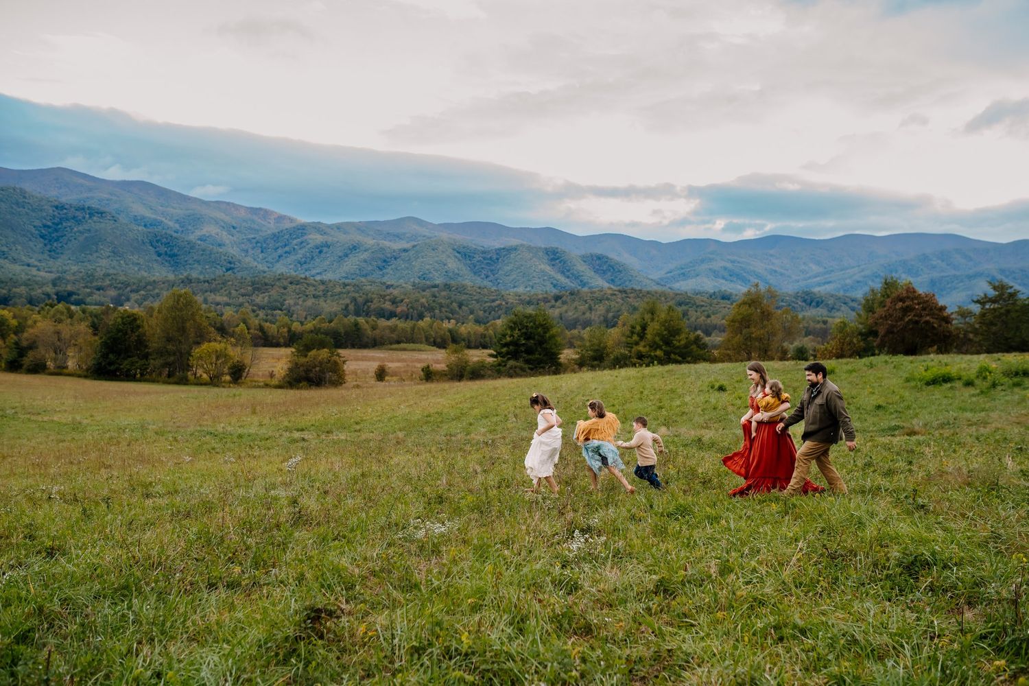 Family walks through a field in Cades Cove