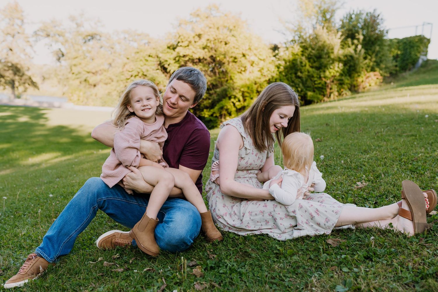 Young family plays in the grass during the summer