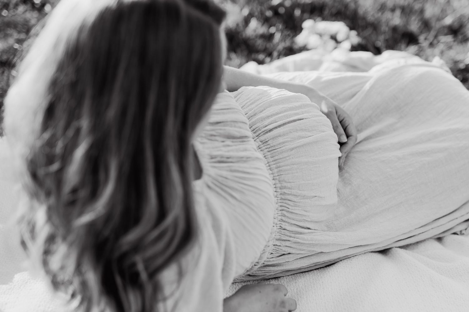 Mom laying on the ground looking at her bump during knoxville maternity photos