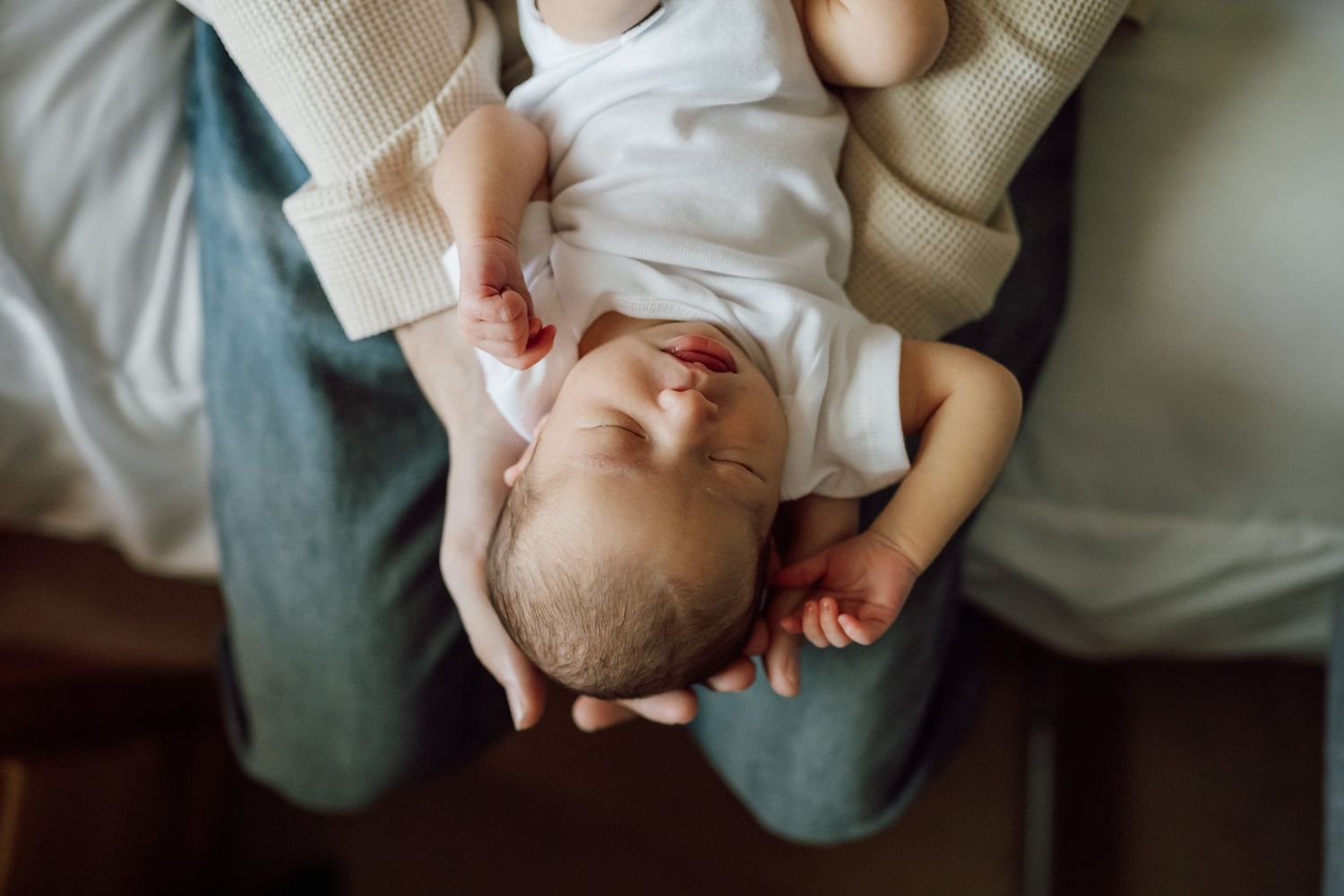 Newborn baby lays in dad's hands during lifestyle newborn session