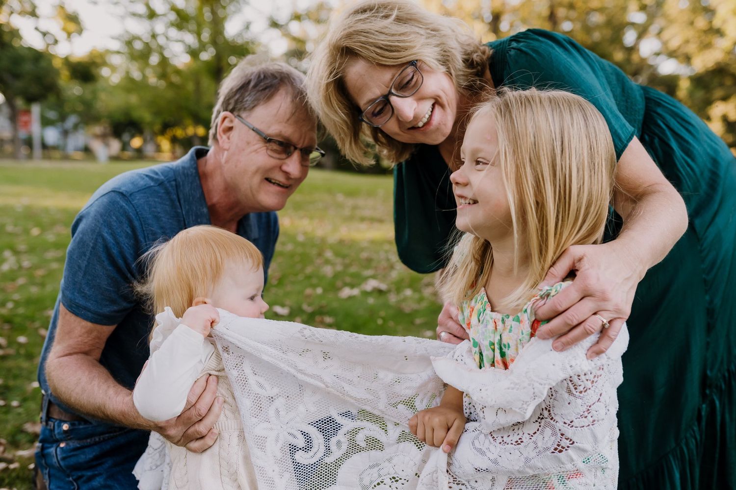 Grandma and grandpa play a game with their two young granddaughters