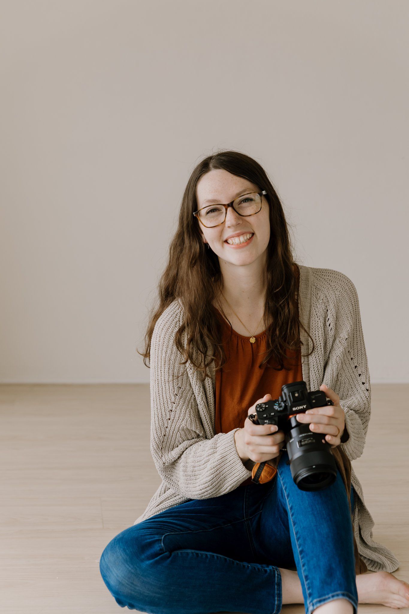 Woman holds camera and smiles