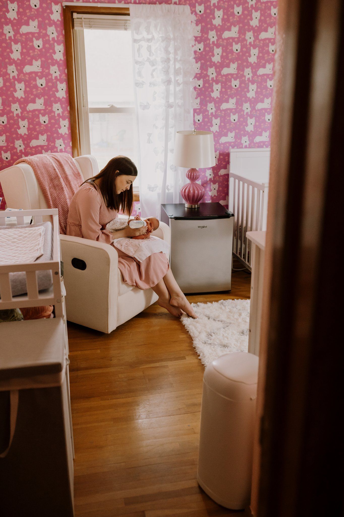 New mother sits in the nursery and feeds her newborn