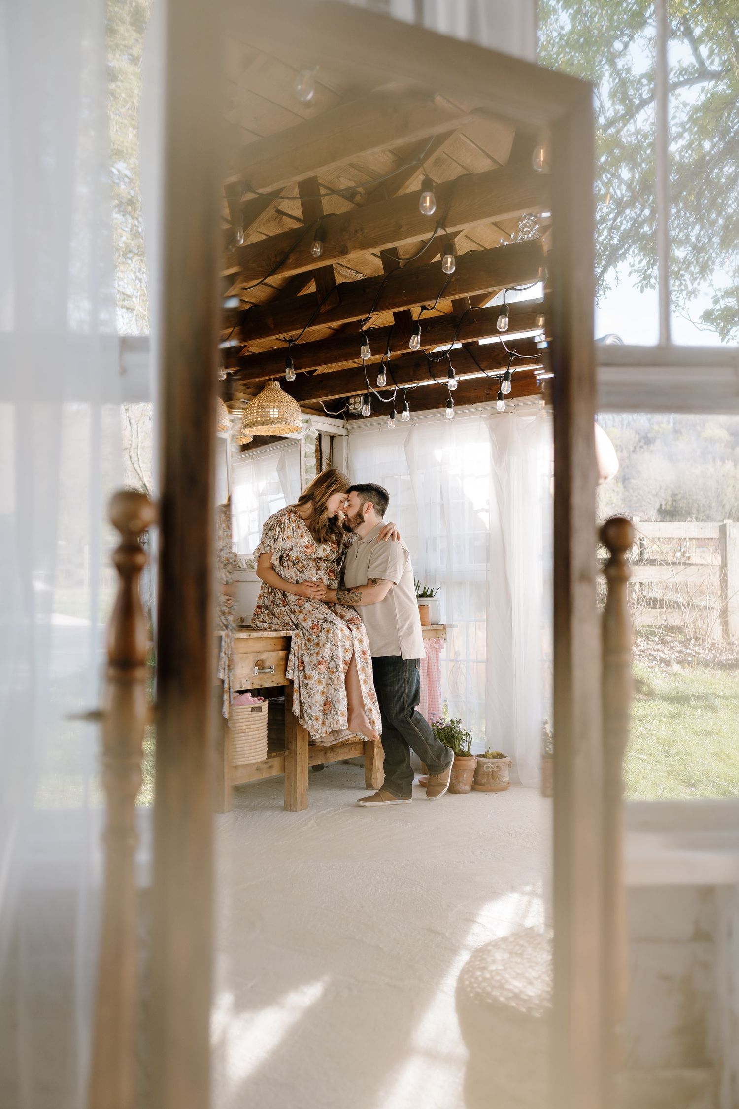 Couple sits during maternity photos at the holmstead studio