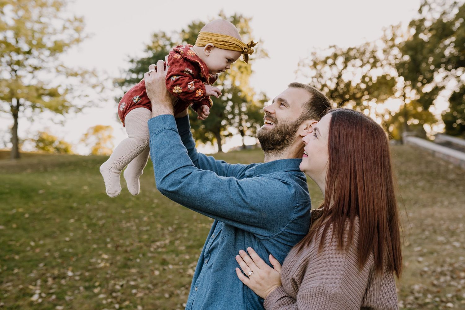 Parents play with baby at golden hour