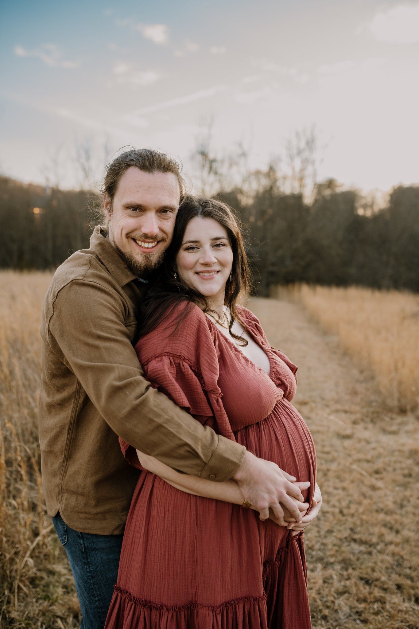winter maternity photo of a mom and her husband hugging and smiling at the camera in knoxville tn