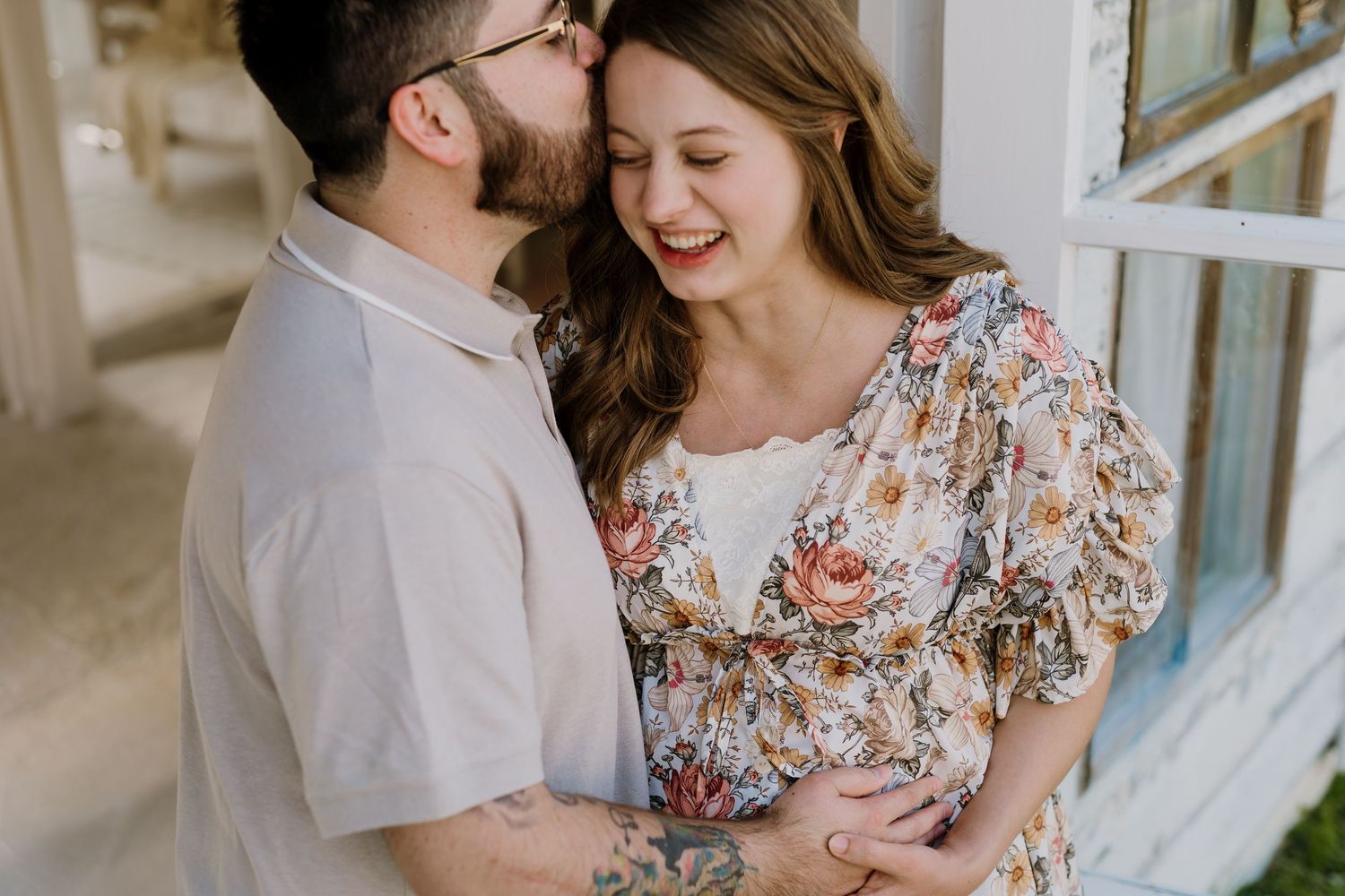 Man kisses a laughing pregnant woman