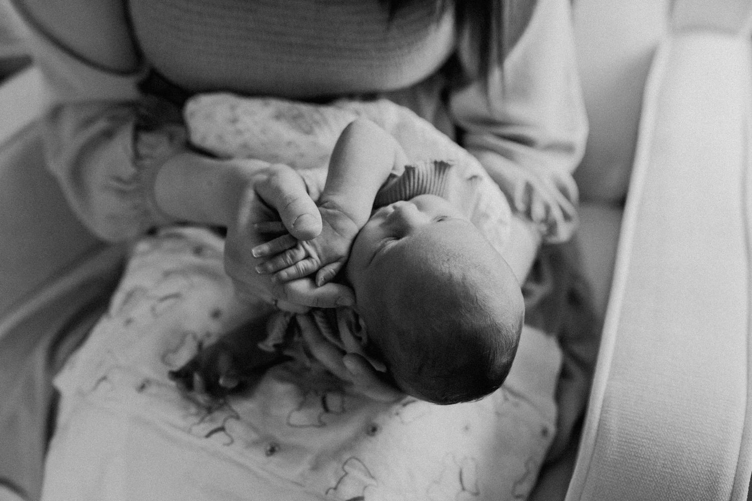 Mom holds newborn and plays with her hands during Maryville newborn photography session