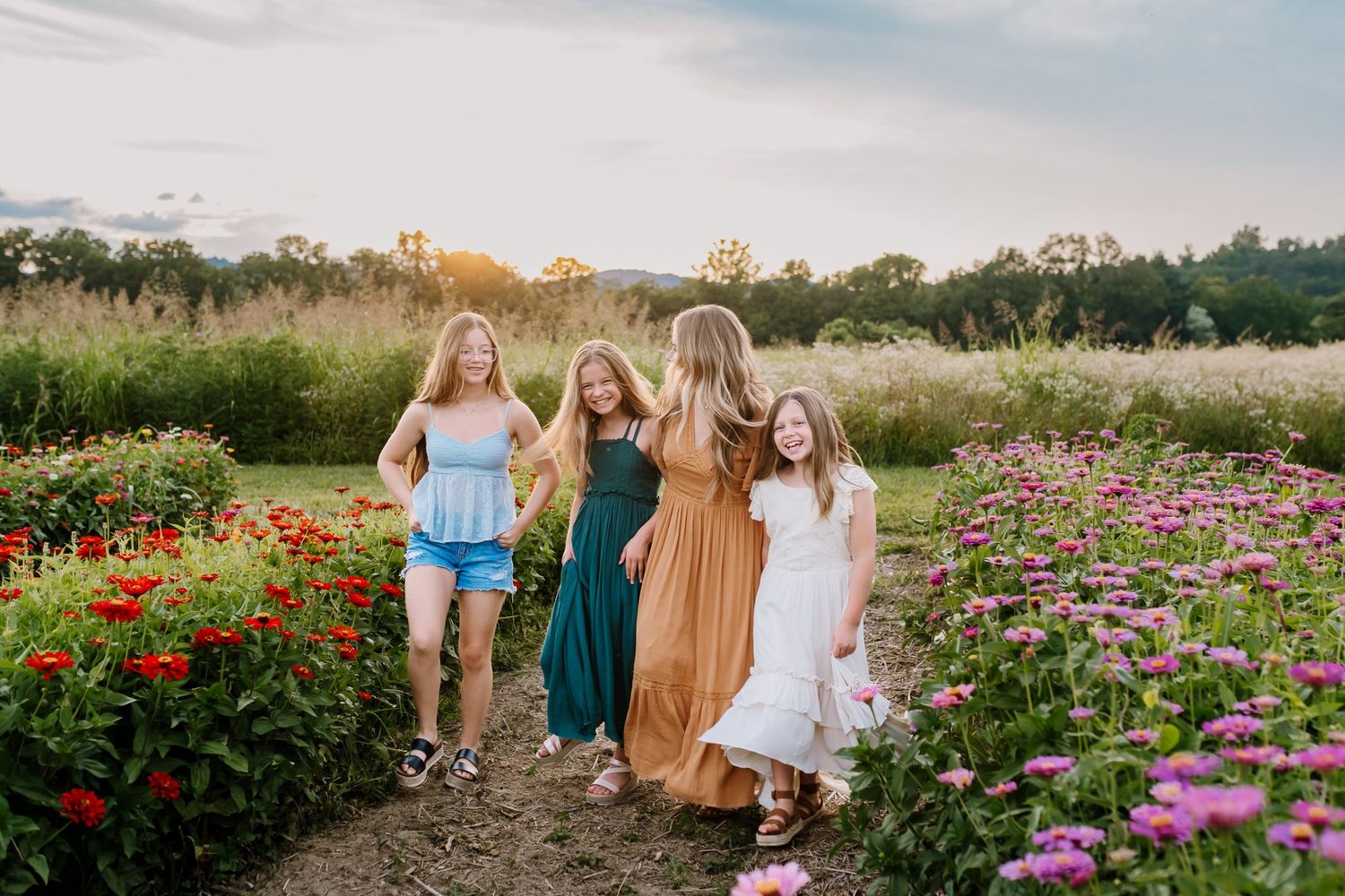 Mom walks through flower field in knoxville tn during motherhood photos with her daughters