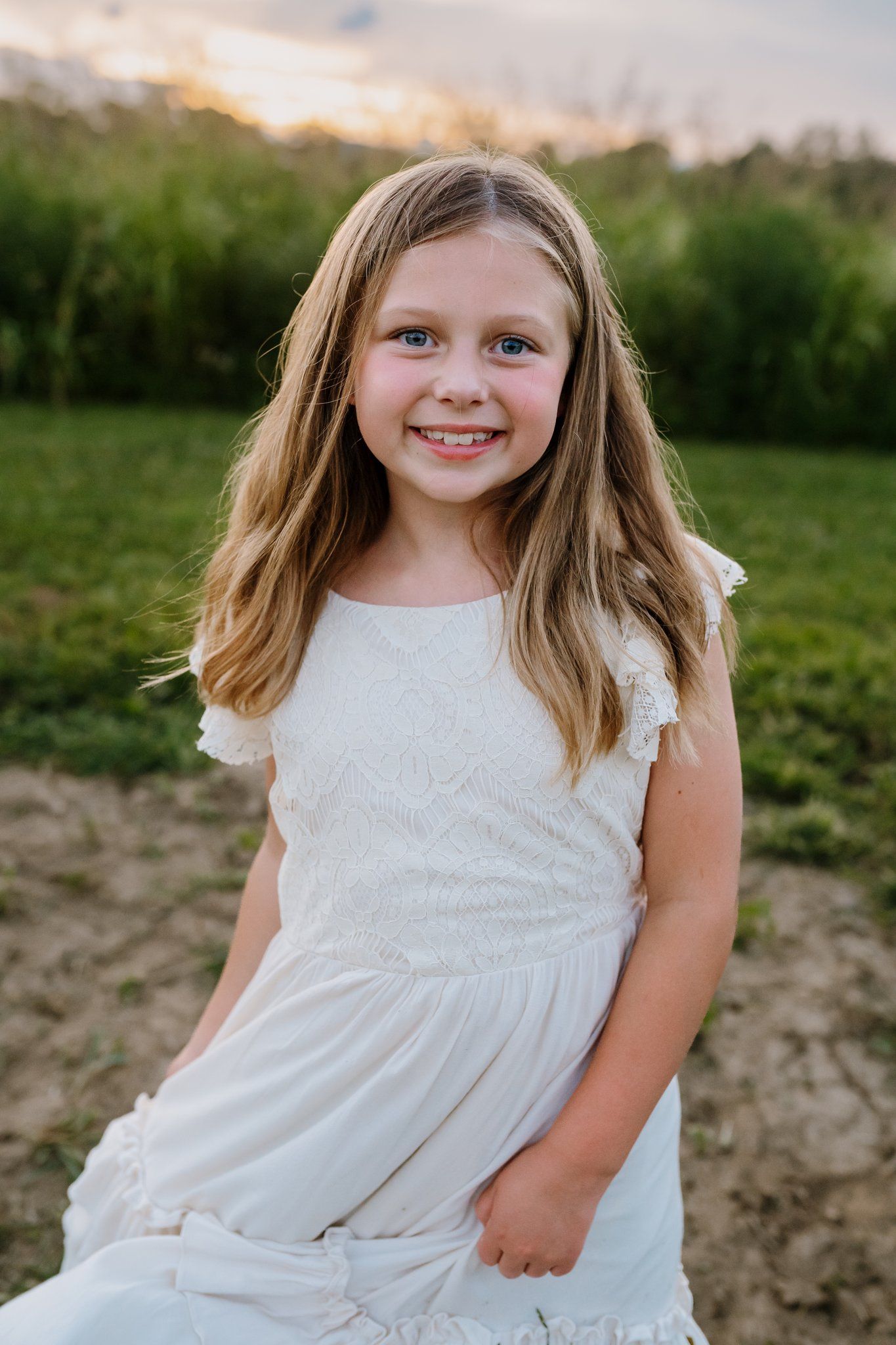 8 year old smiles at camera as she swishes her skirt
