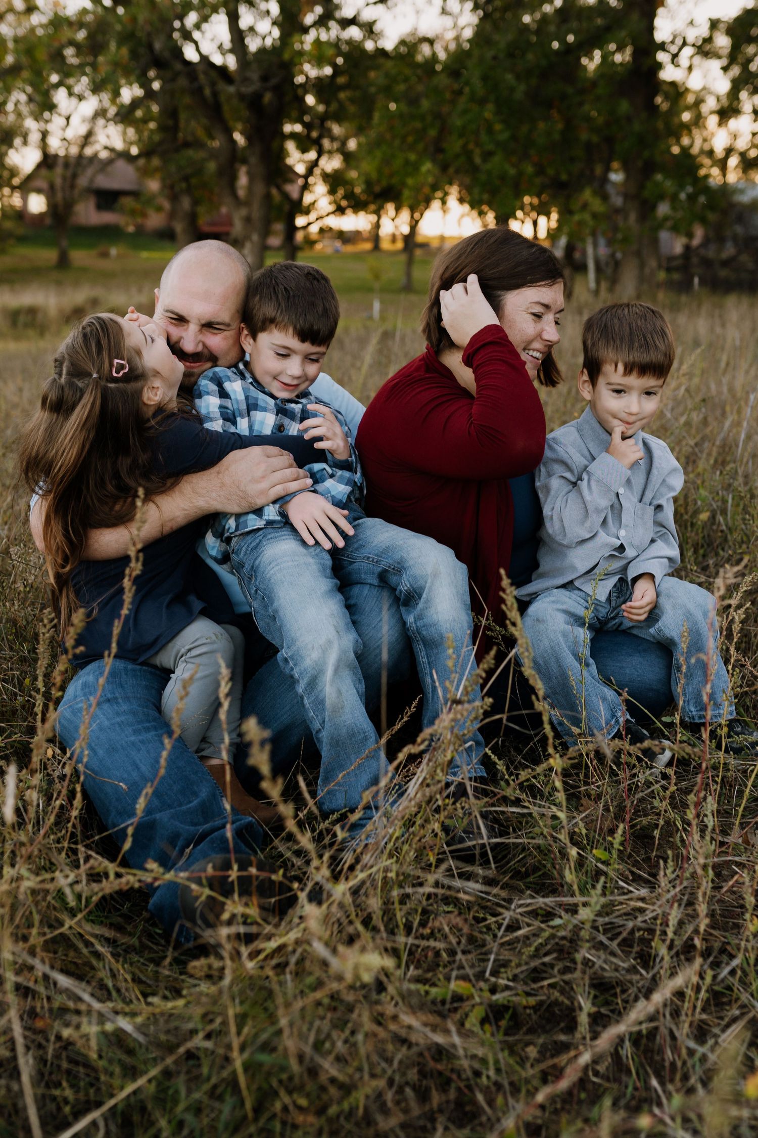 Family of five laughs together with family photographer in Maryville