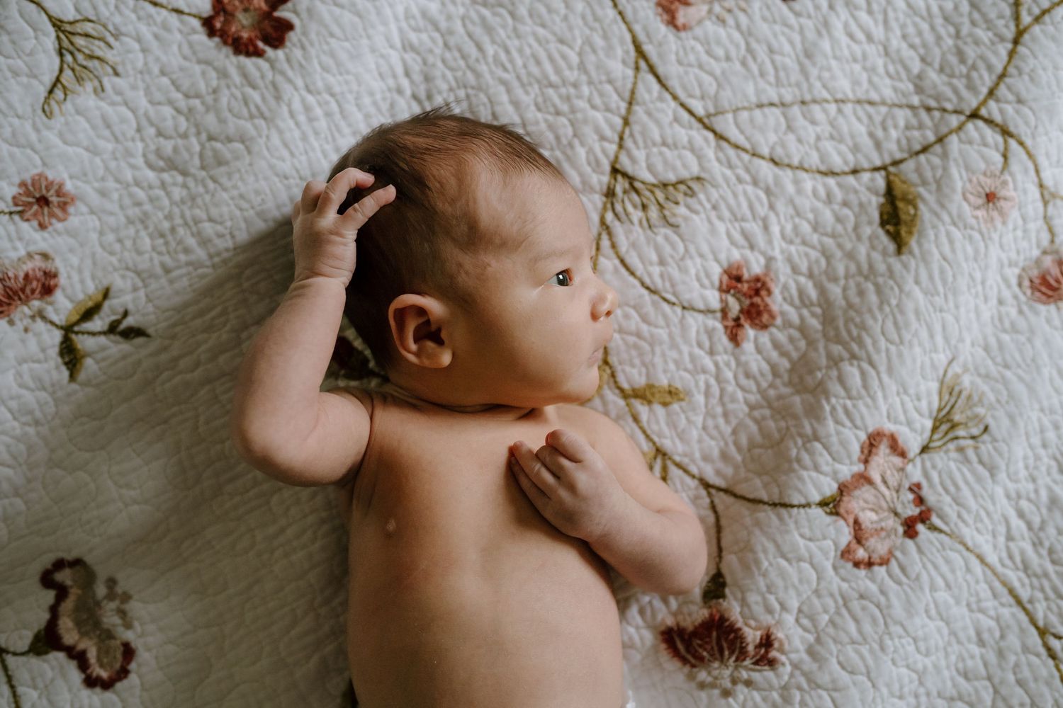 Newborn baby lying on bed during newborn photos