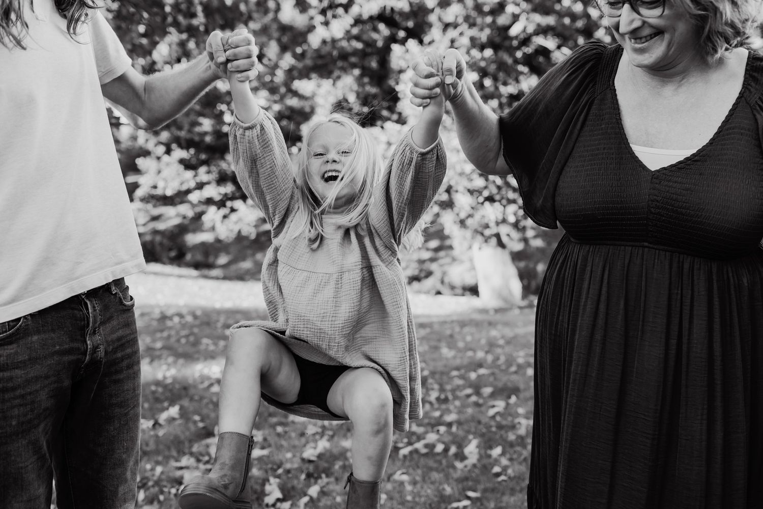 Grandma and uncle swing four year old playfully between them as they walk
