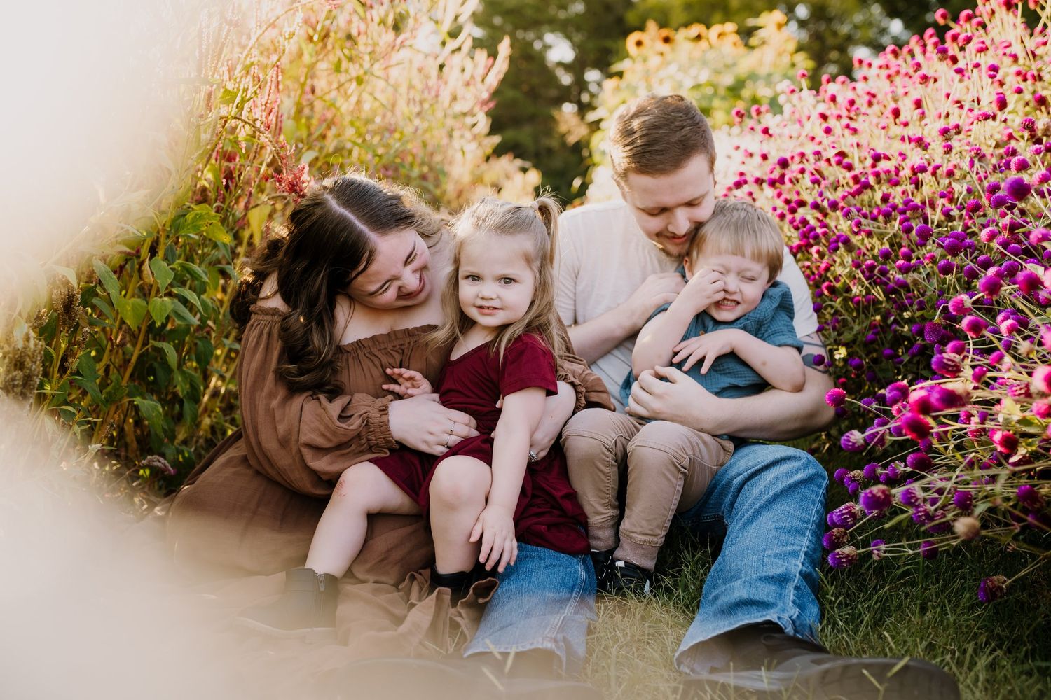 Family sits with toddlers for joyful family photos in maryville tn flower field