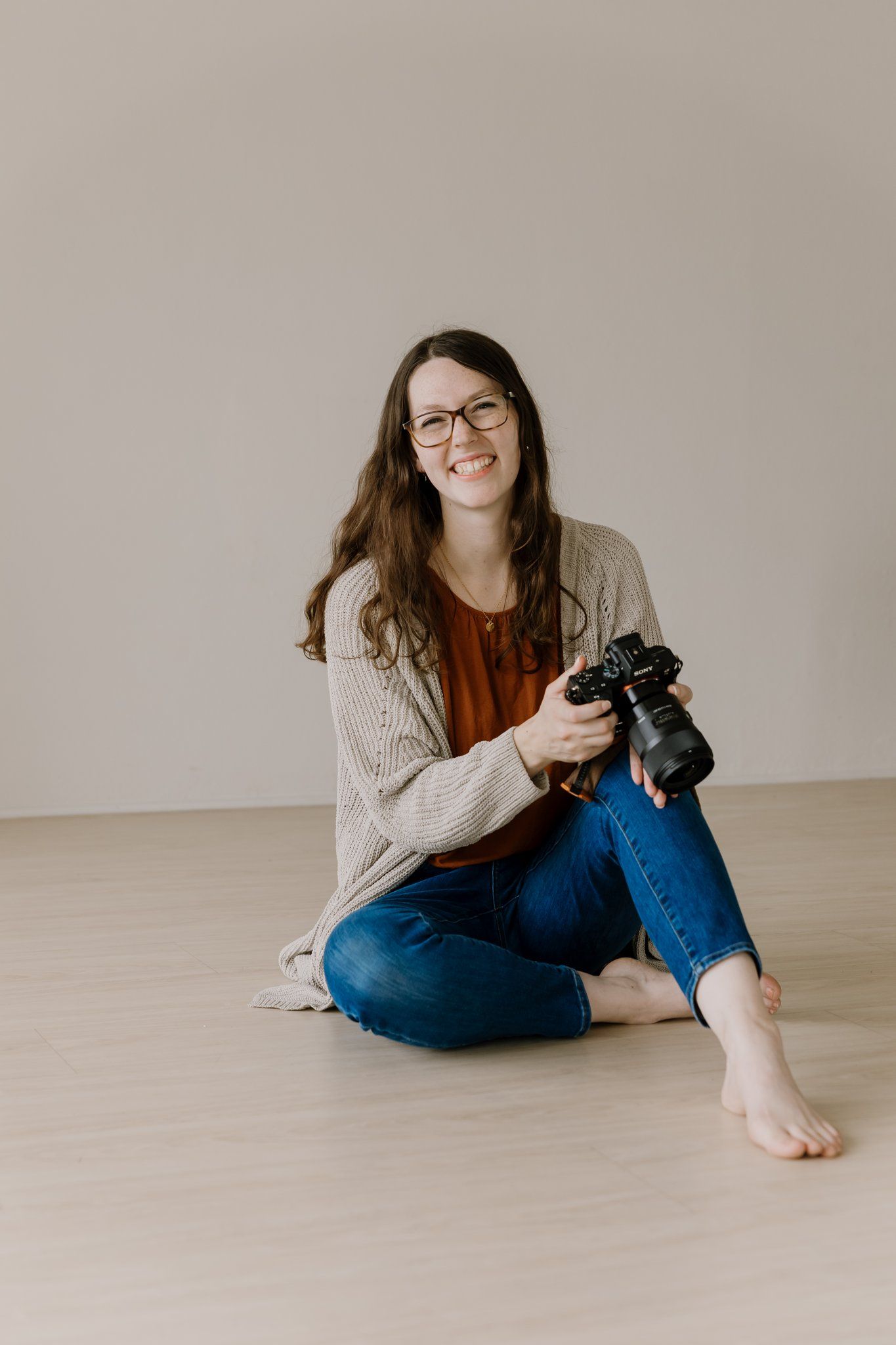 Susannah smiles at the camera while holding her Sony camera