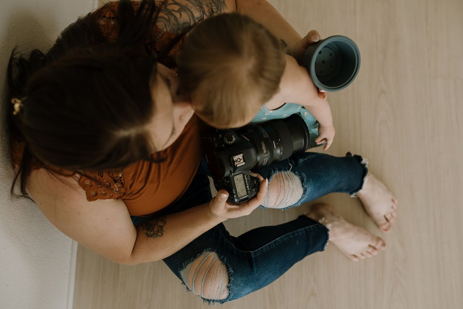 Woman holds her daughter and her camera