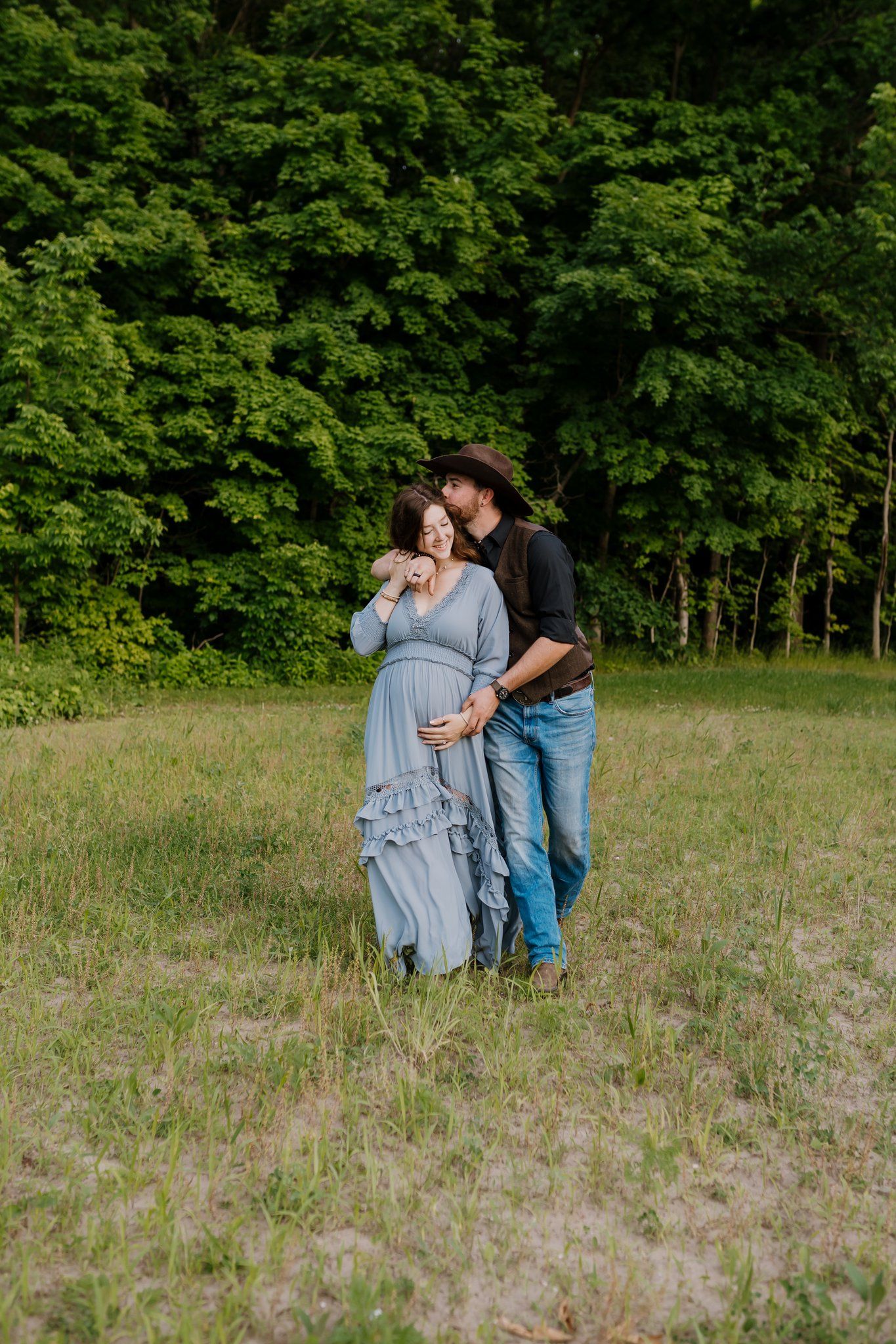 Husband and wife walk through a field